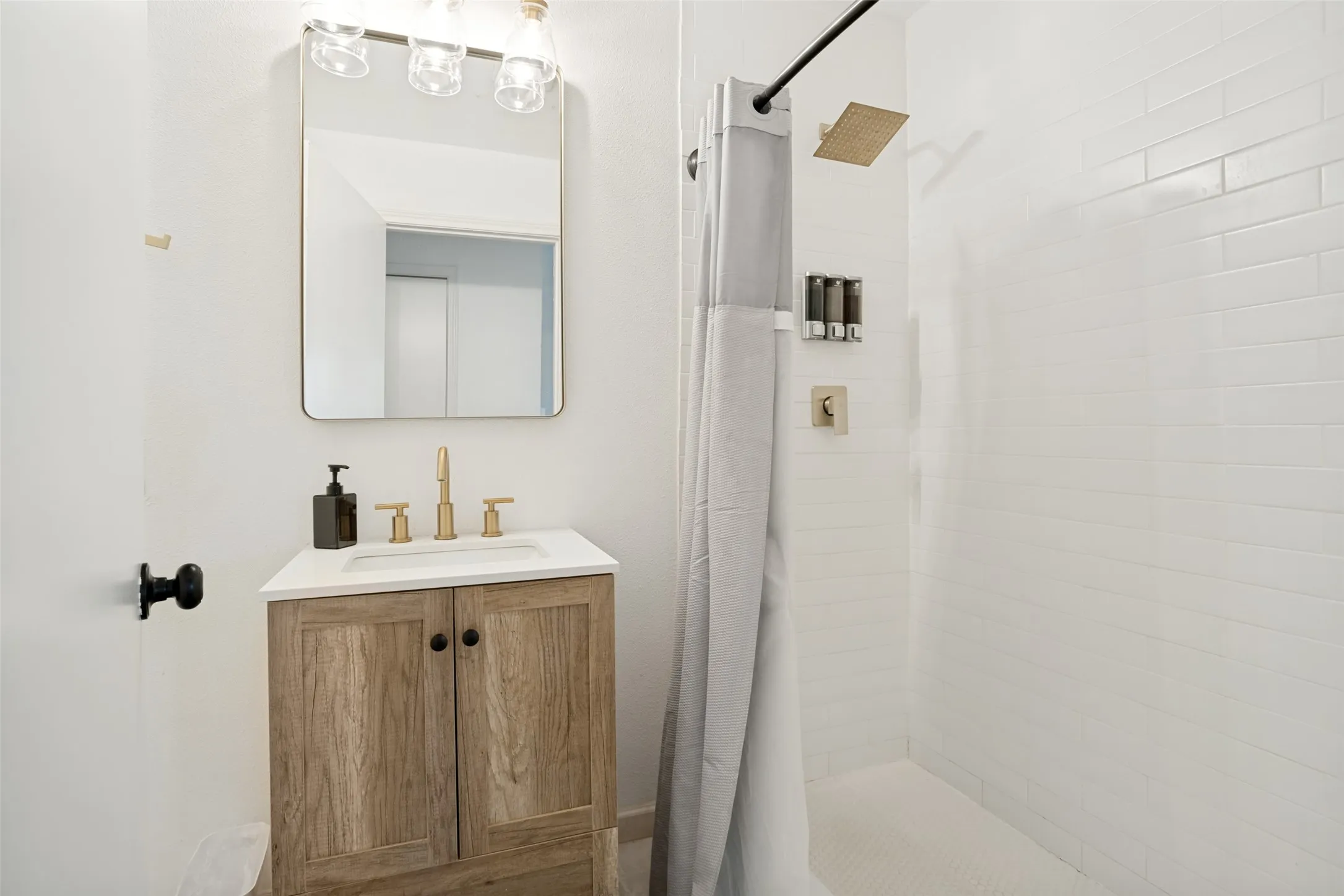 Bathroom featuring a wood-finish vanity with a white countertop and gold-tone faucet