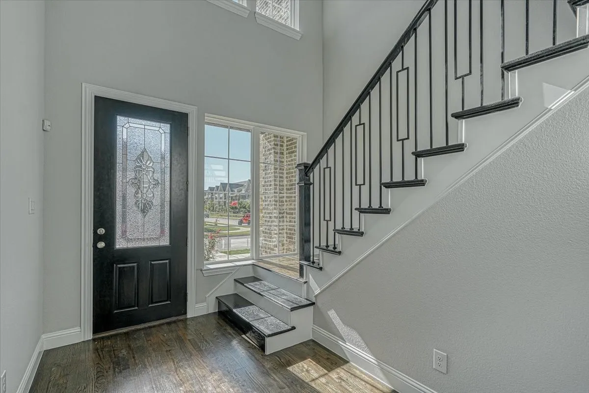 Foyer entrance featuring a high ceiling and dark wood-type flooring