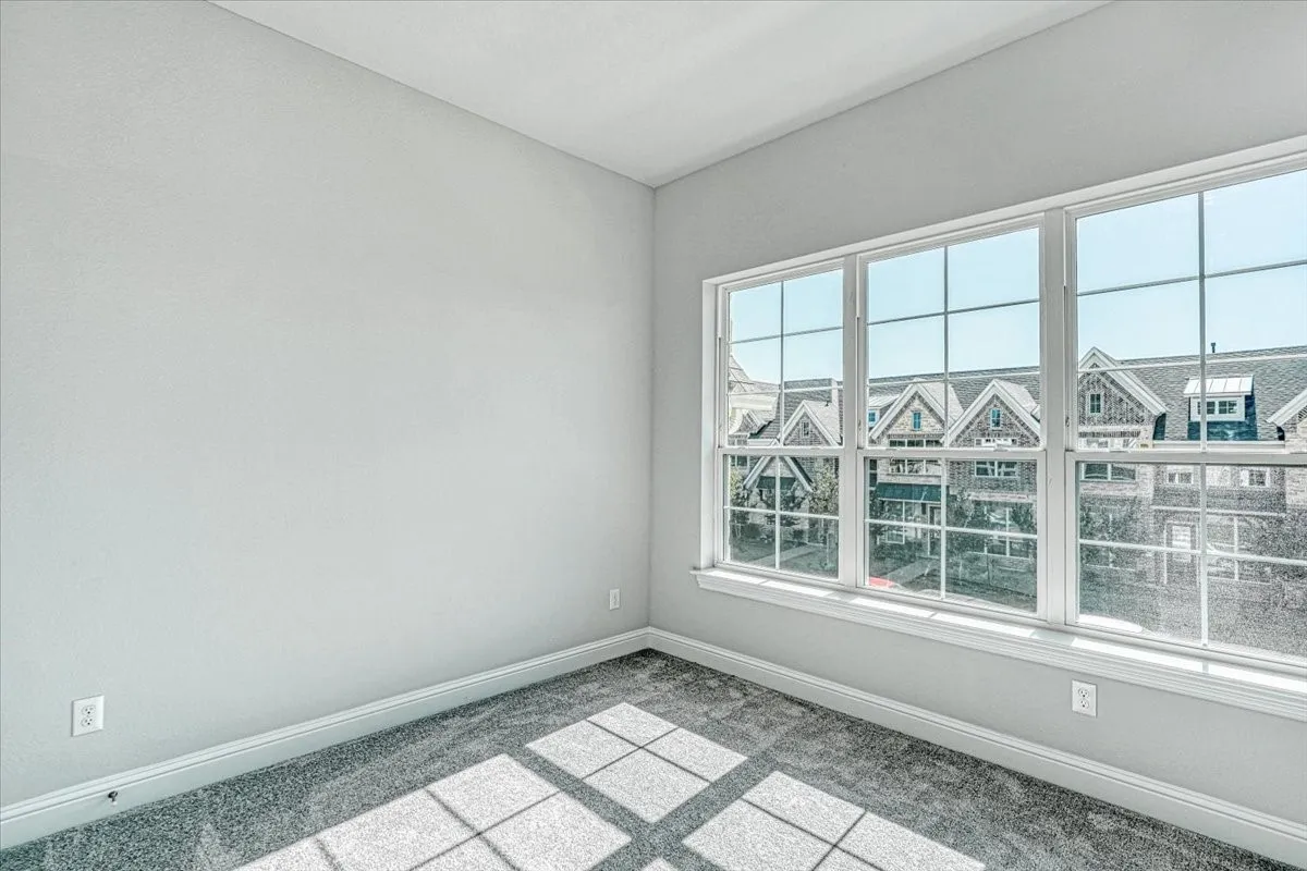 Empty room featuring a healthy amount of sunlight and carpet flooring