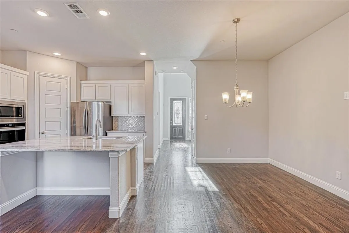 Kitchen featuring hanging light fixtures, dark hardwood / wood-style floors, backsplash, and stainless steel appliances