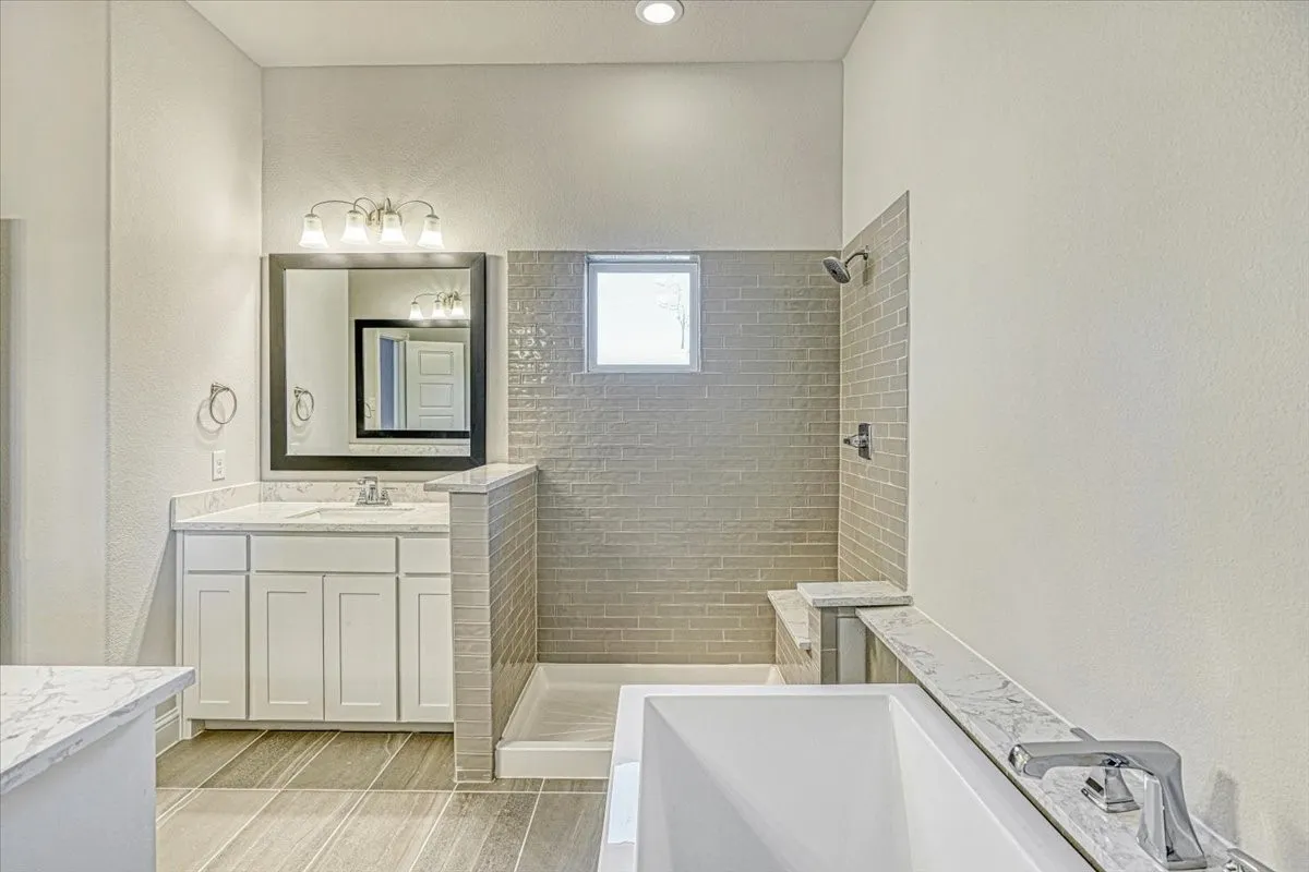 Bathroom featuring tile flooring, separate shower and tub, and vanity