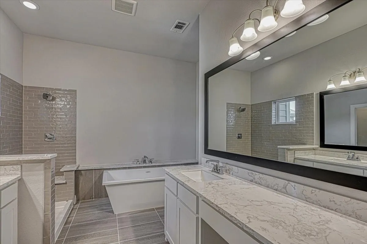 Bathroom featuring tile flooring, separate shower and tub, and vanity