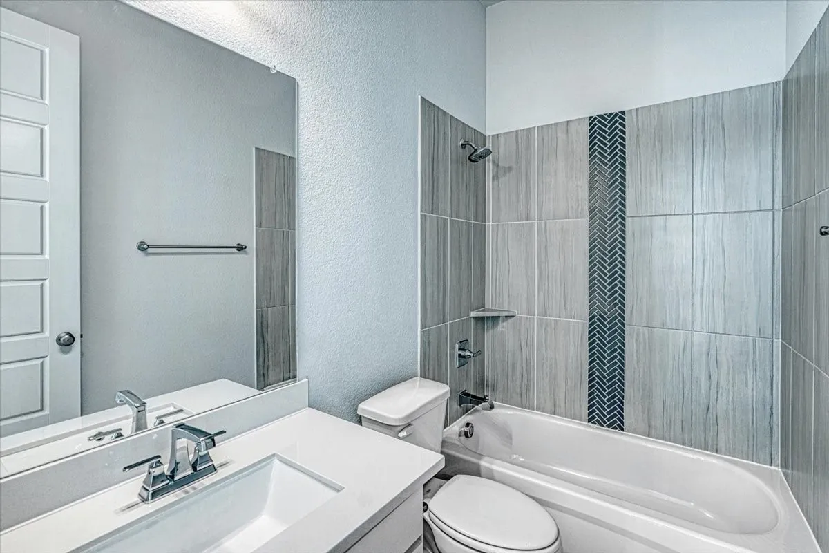 Full bathroom featuring vanity, toilet, and tiled shower / bath combo
