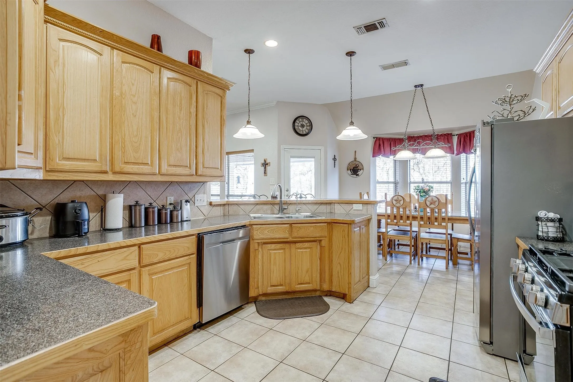 Kitchen with a peninsula, visible vents, a sink, and appliances with stainless steel finishes
