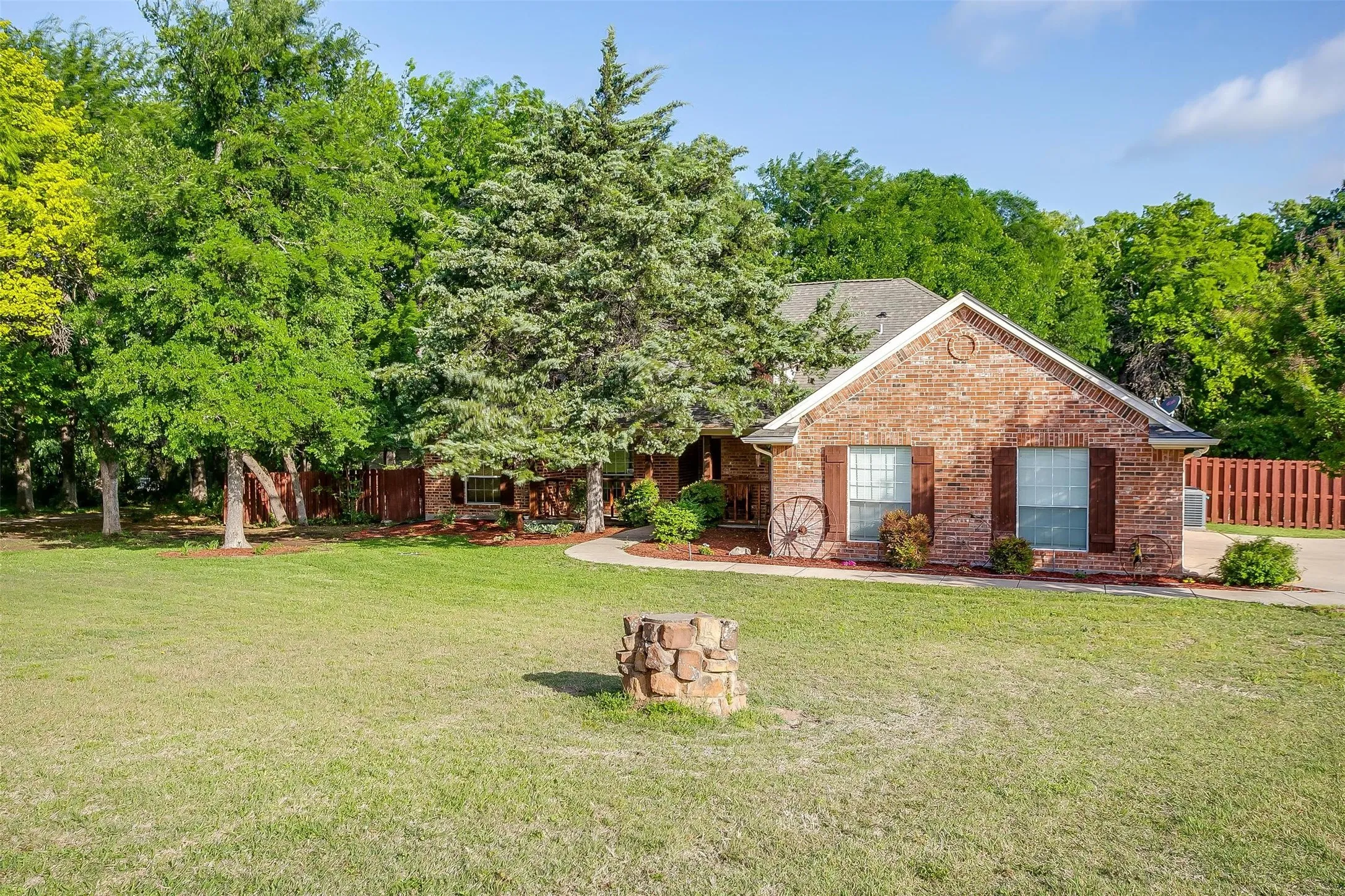 View of front of home with brick siding, fence, and a front yard
