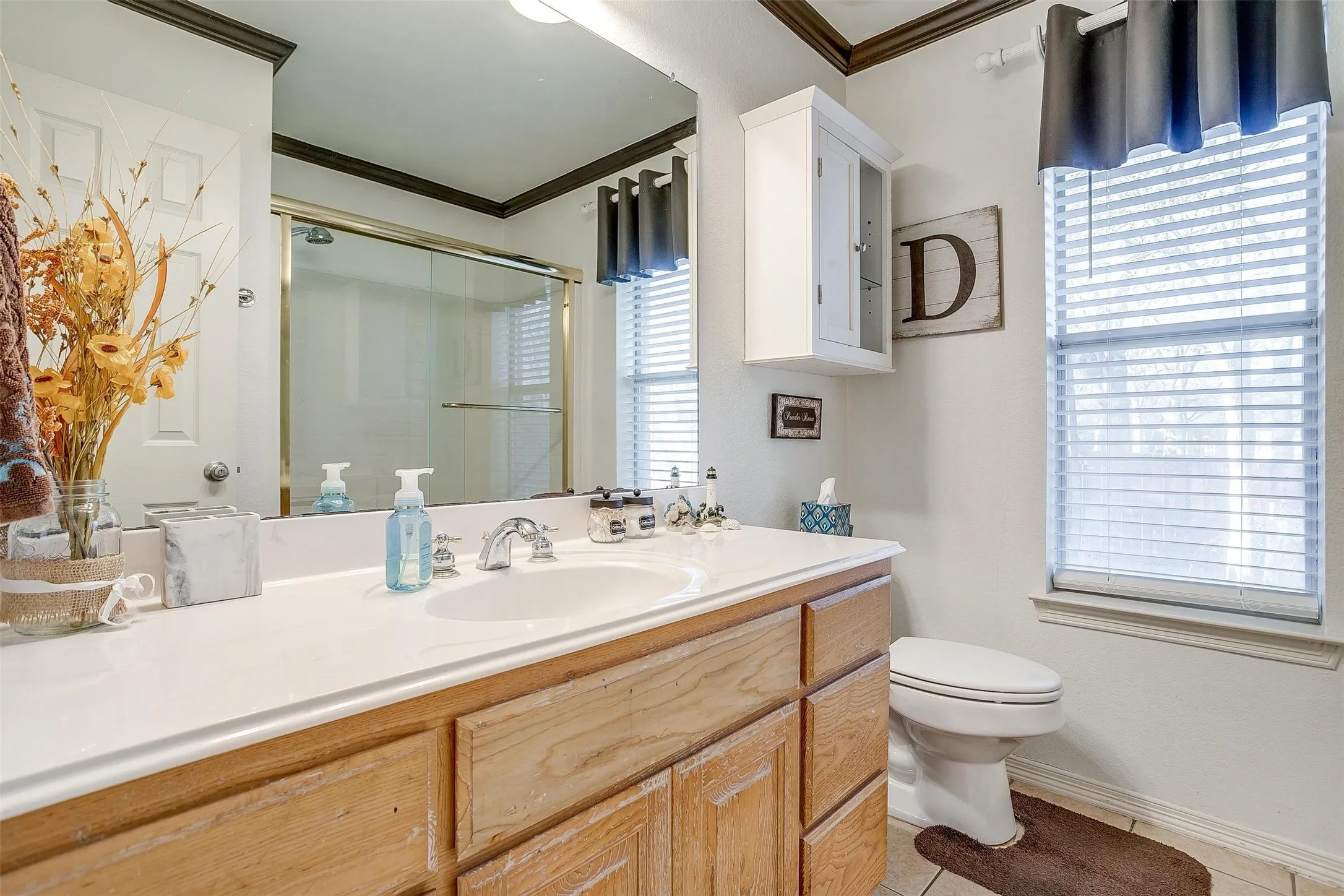 Full bath featuring crown molding, a stall shower, vanity, toilet, and tile patterned flooring