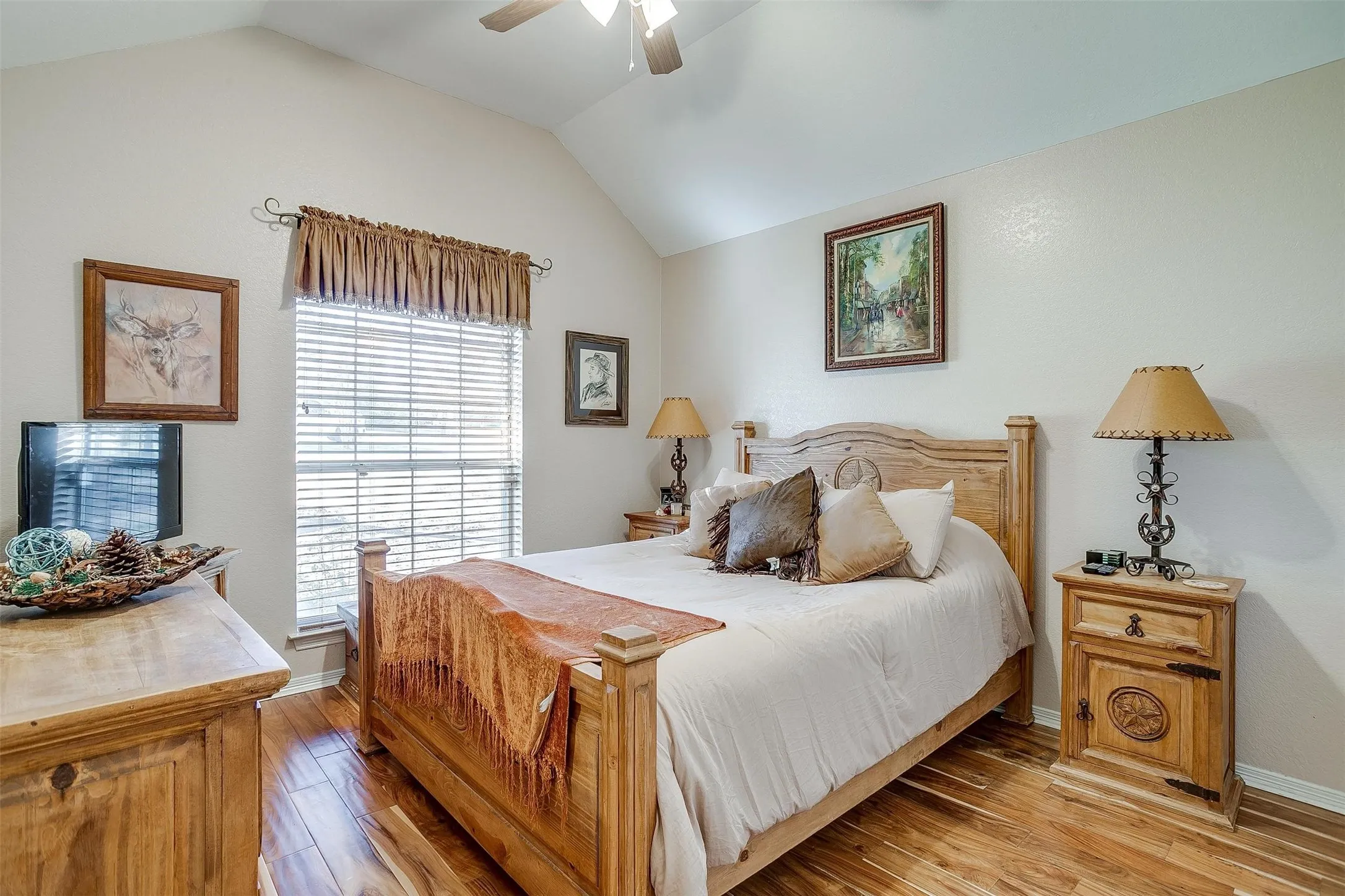 Bedroom with lofted ceiling, a ceiling fan, baseboards, and light wood-type flooring