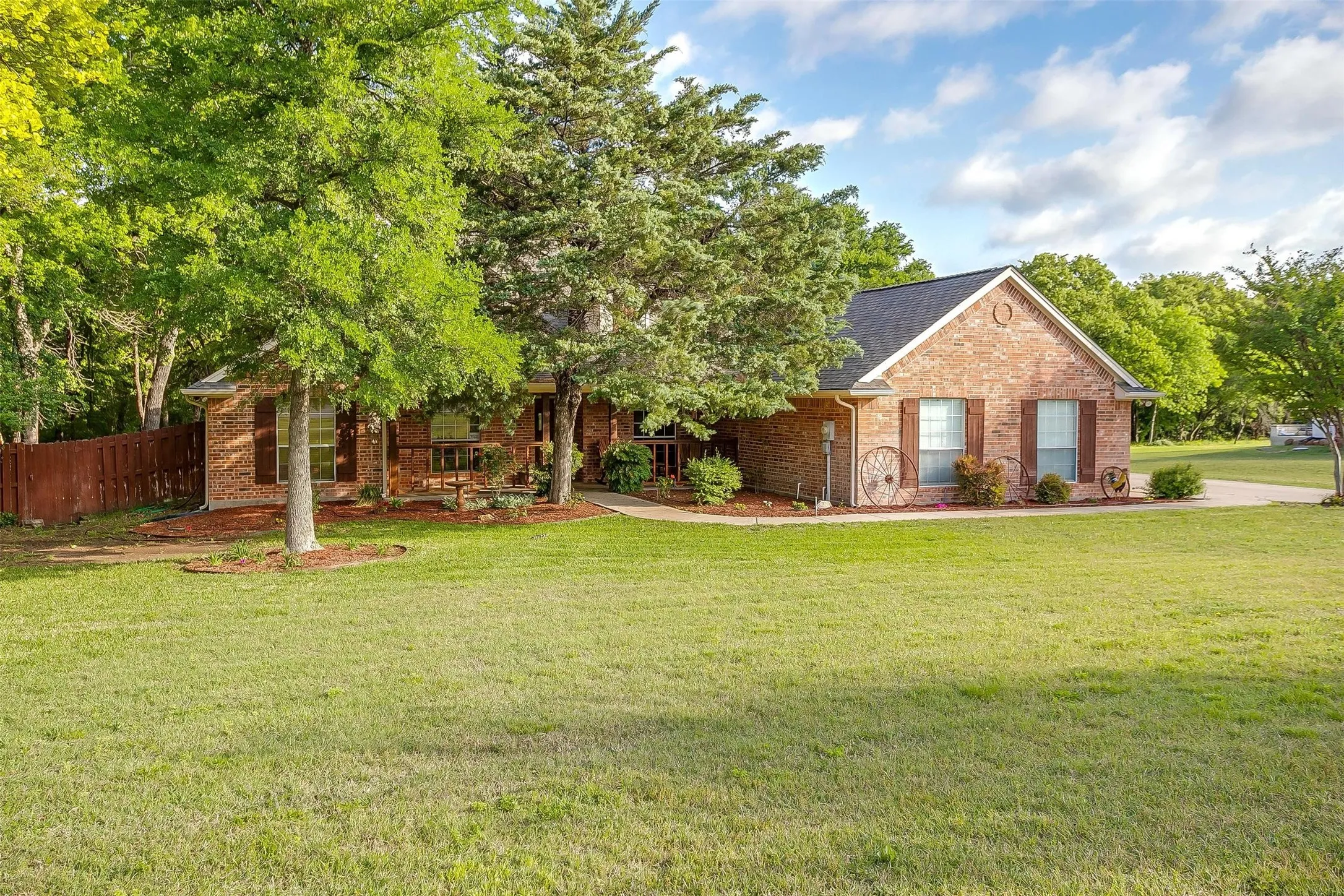 View of front of home featuring fence, a shingled roof, a front lawn, and brick siding