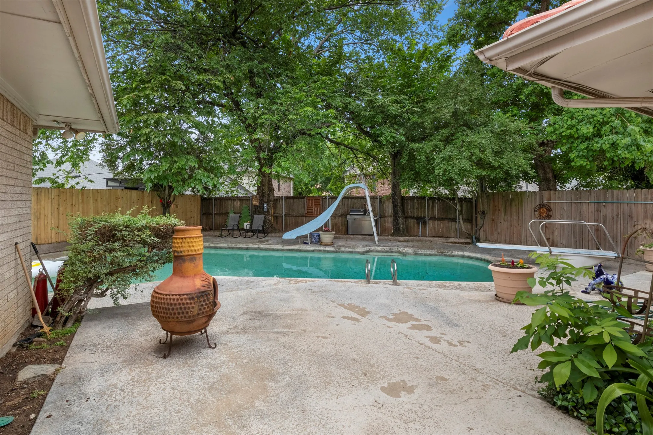 Spacious concrete patio surrounding an in-ground swimming pool
