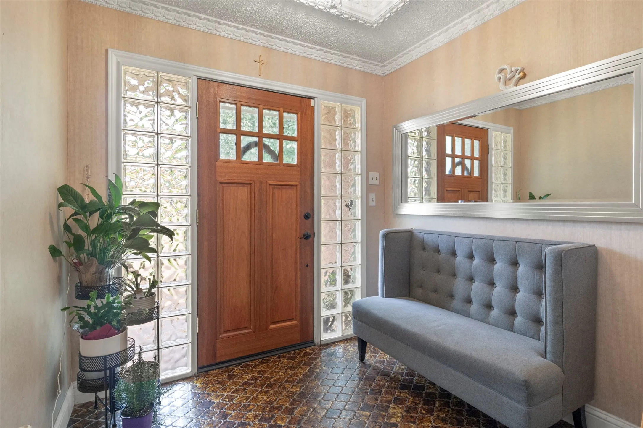 Entryway featuring a wood-panel door with divided light windows, flanked by glass block sidelights