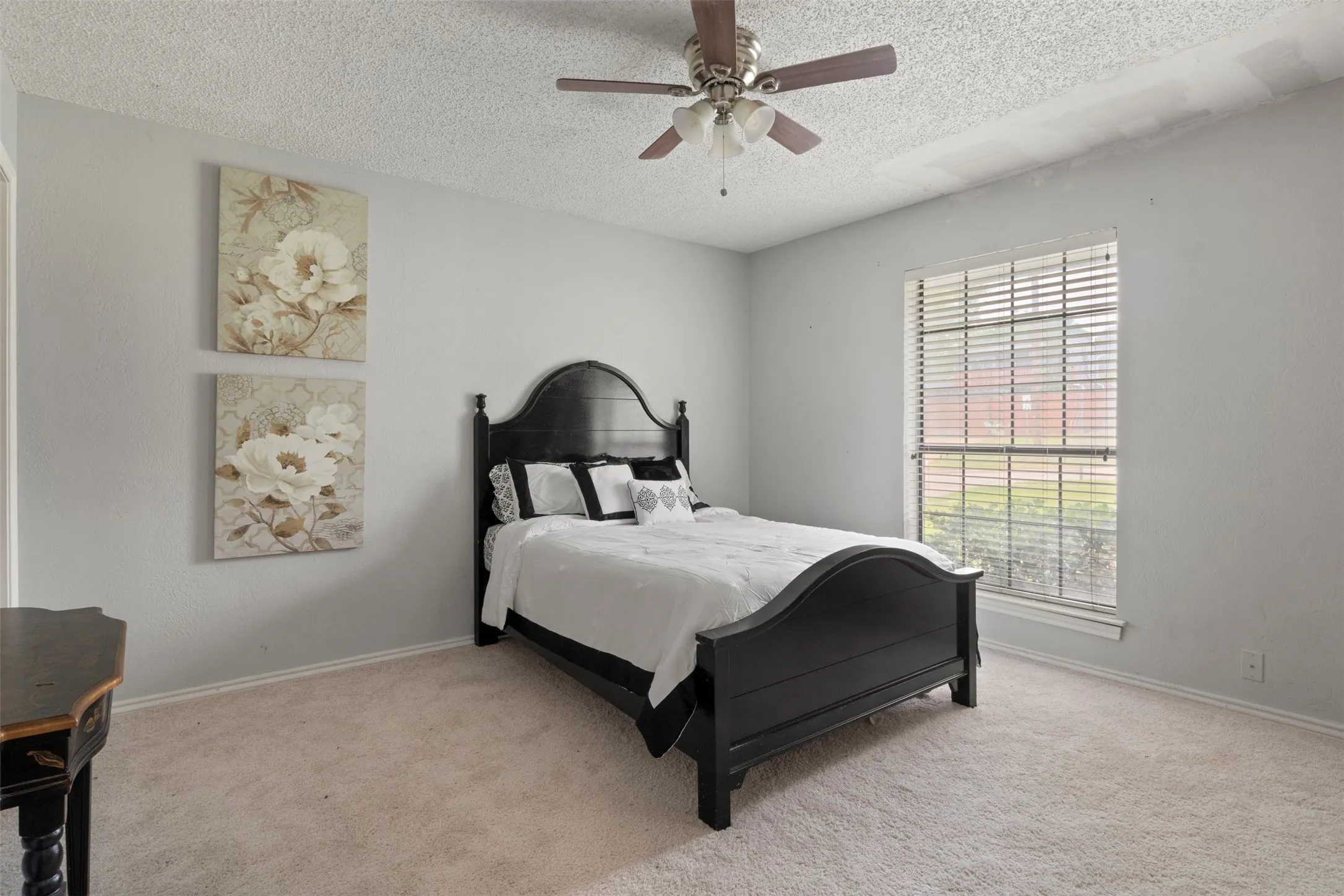 Carpeted room with a ceiling fan light fixture, light gray walls, and a window with blinds