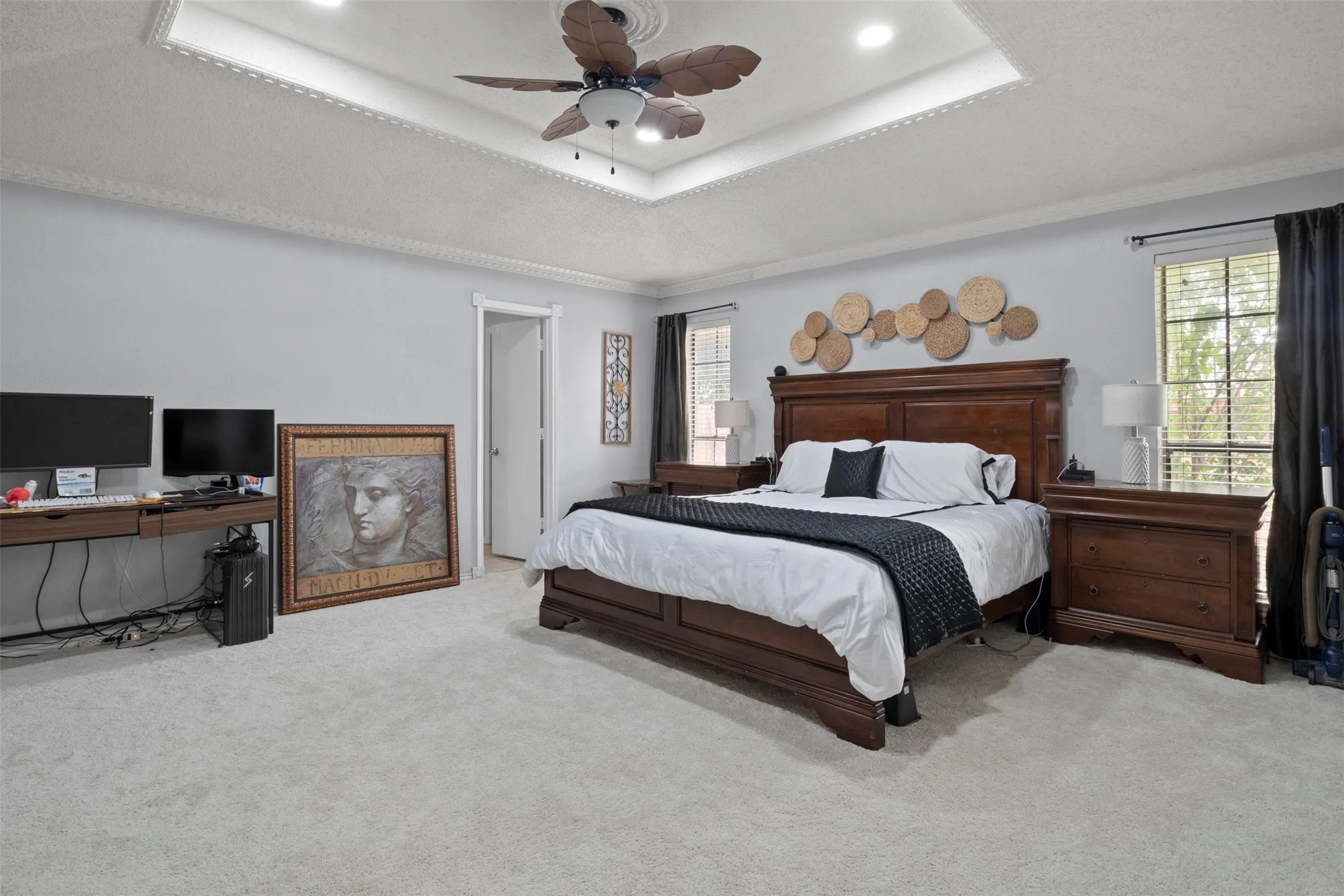 Spacious room featuring light gray wall paint and light-colored carpet flooring