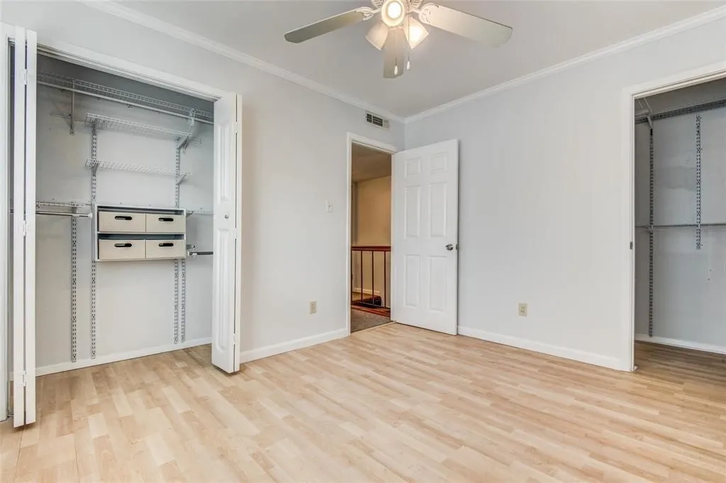 Room featuring light wood-finish flooring and custom closet organization