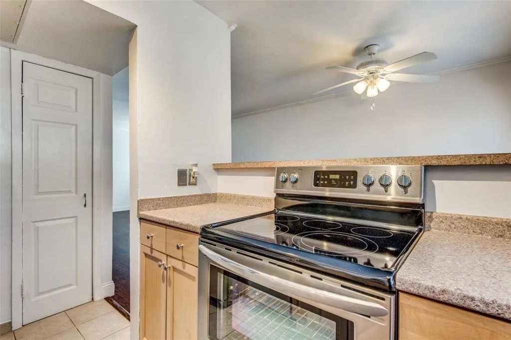 Kitchen featuring stainless steel range, light wood-finish cabinetry