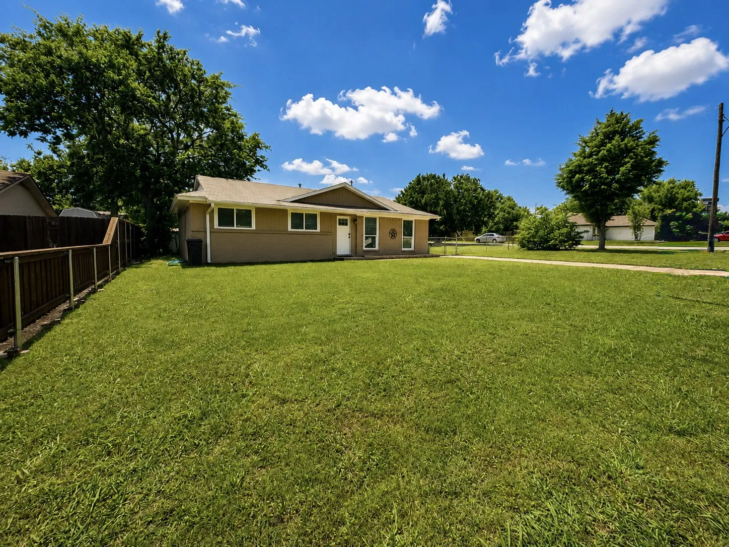 Expansive front yard with a large green lawn