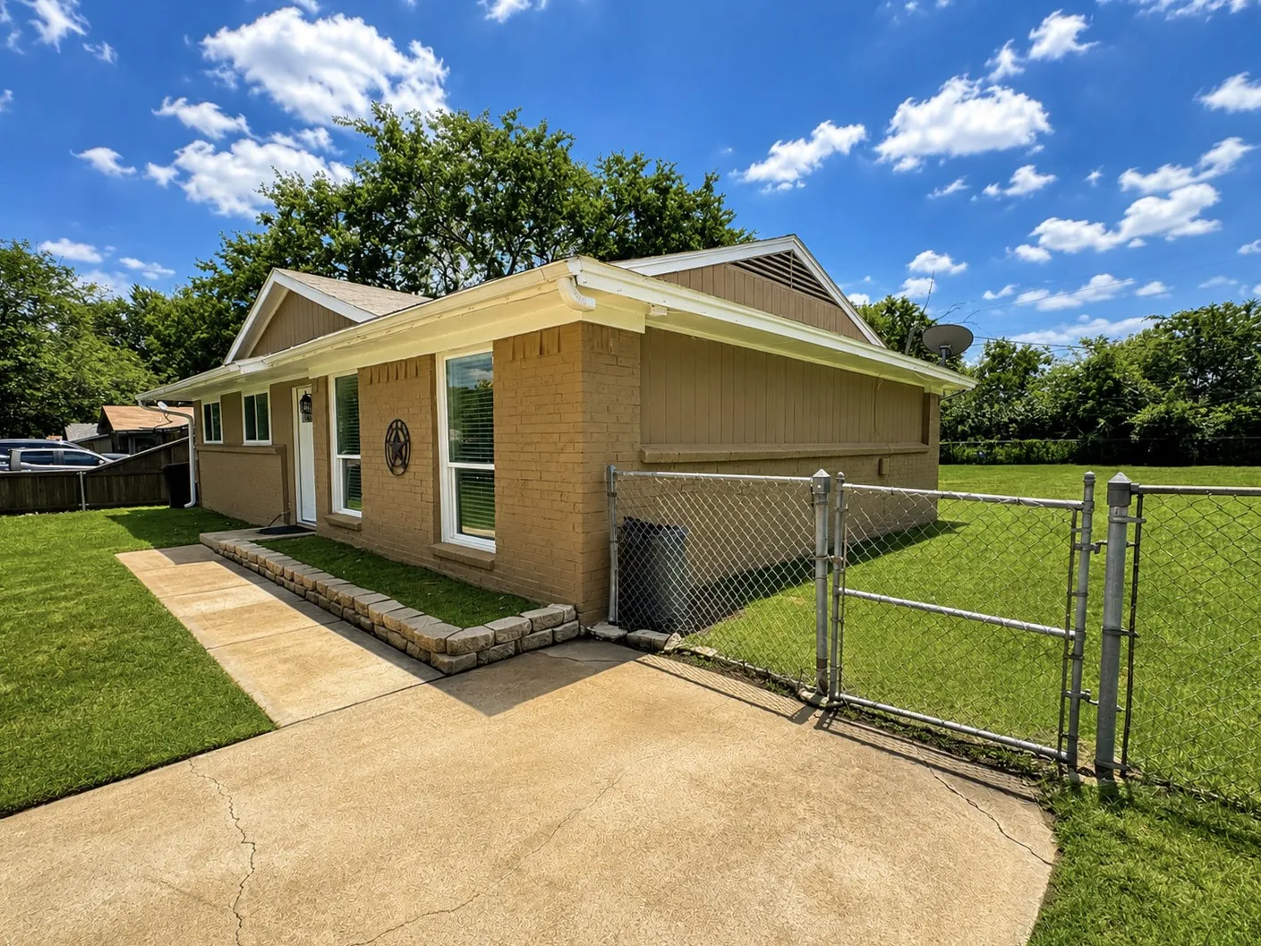 Brick and siding exterior with a concrete walkway and driveway