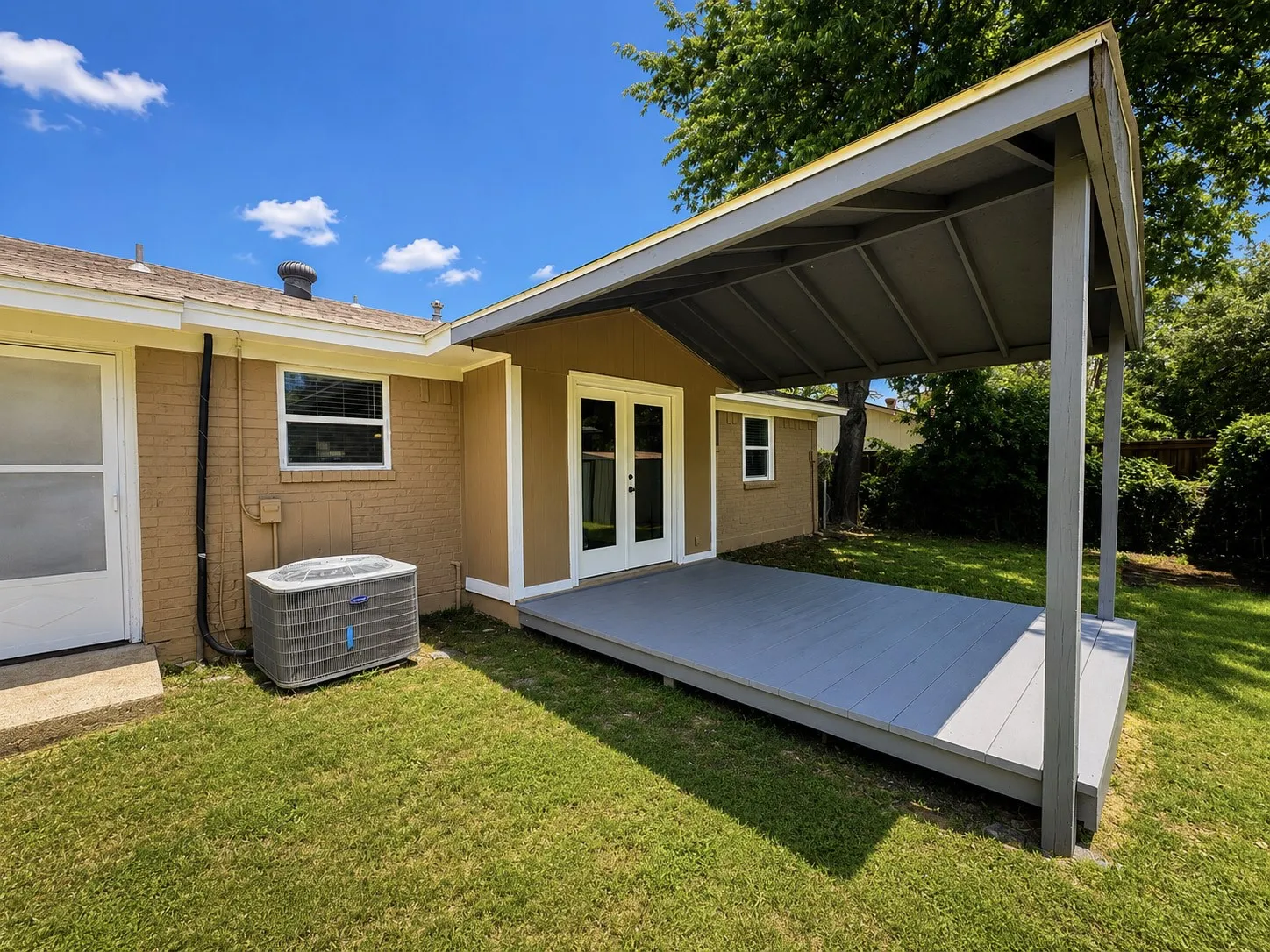 Expansive covered patio featuring a gray-painted deck and supporting columns