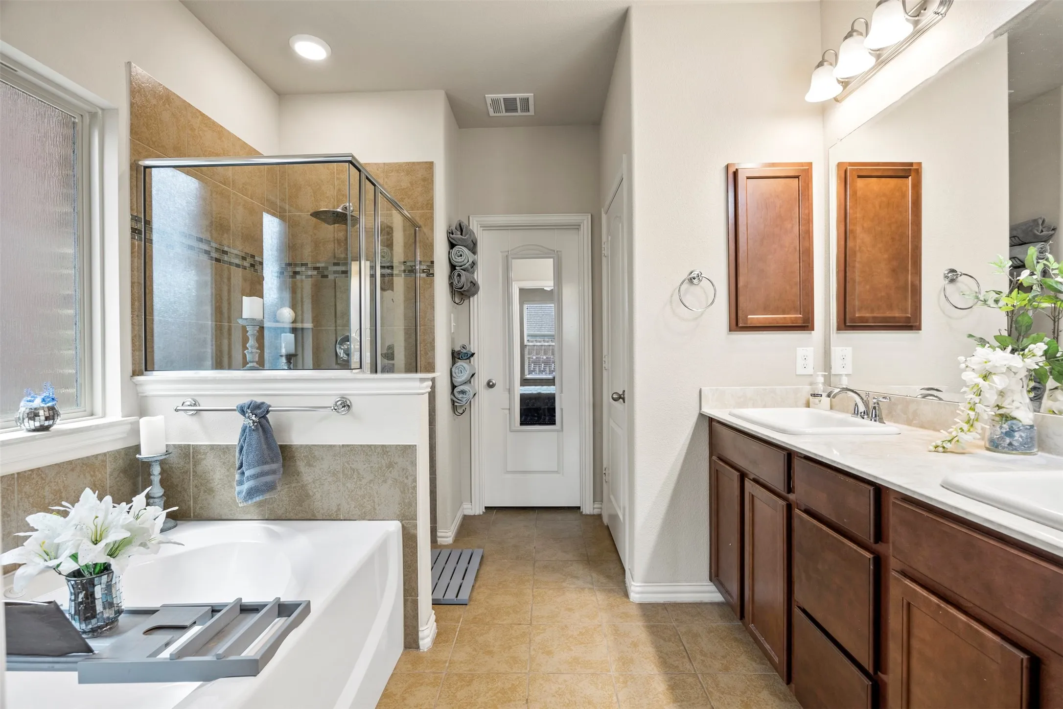 Dual vanity with integrated sinks, framed mirror, and warm wood-finish cabinetry