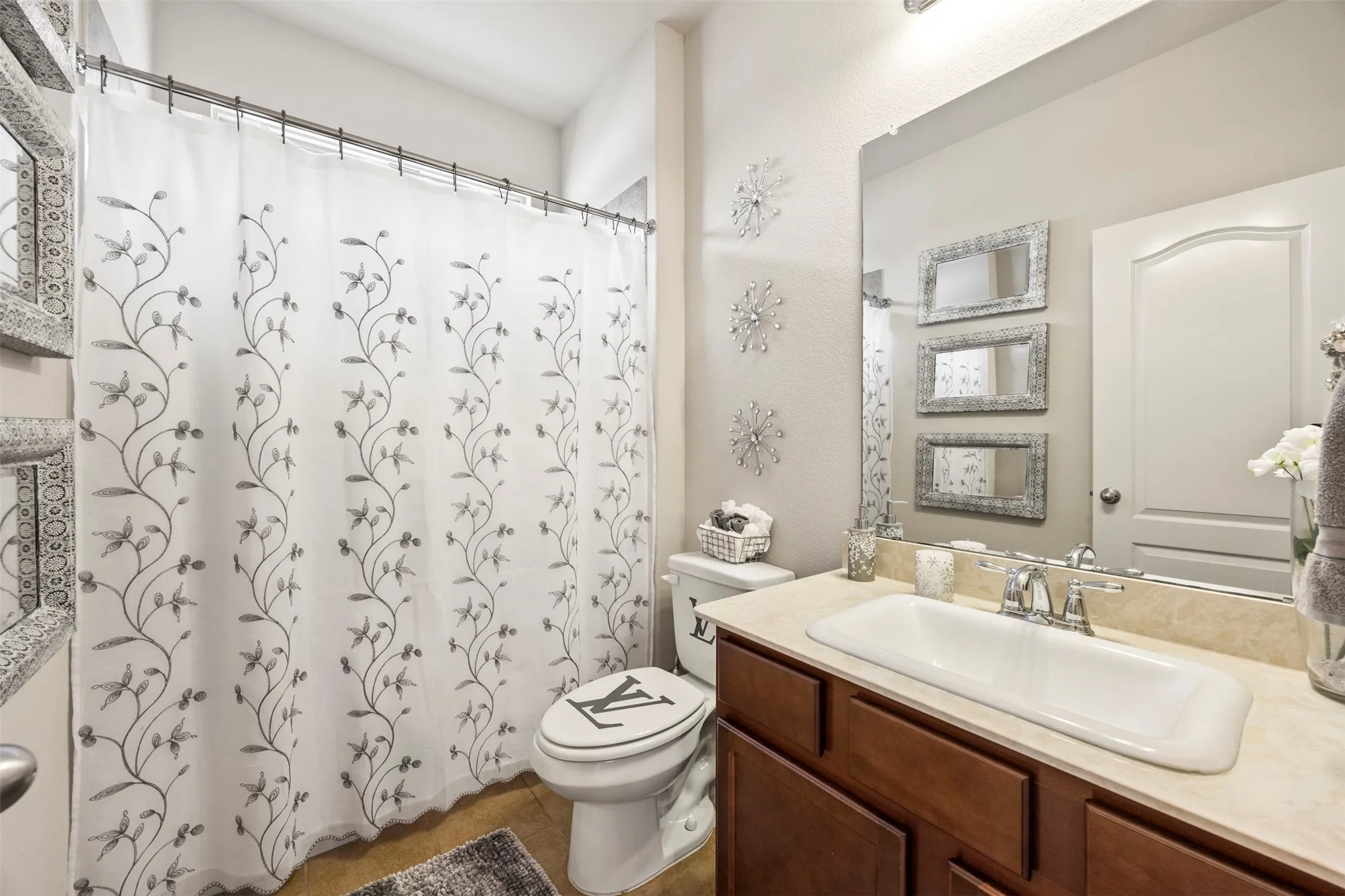 Bathroom featuring a single vanity with wood cabinetry, a light-toned countertop, and an integrated rectangular sink