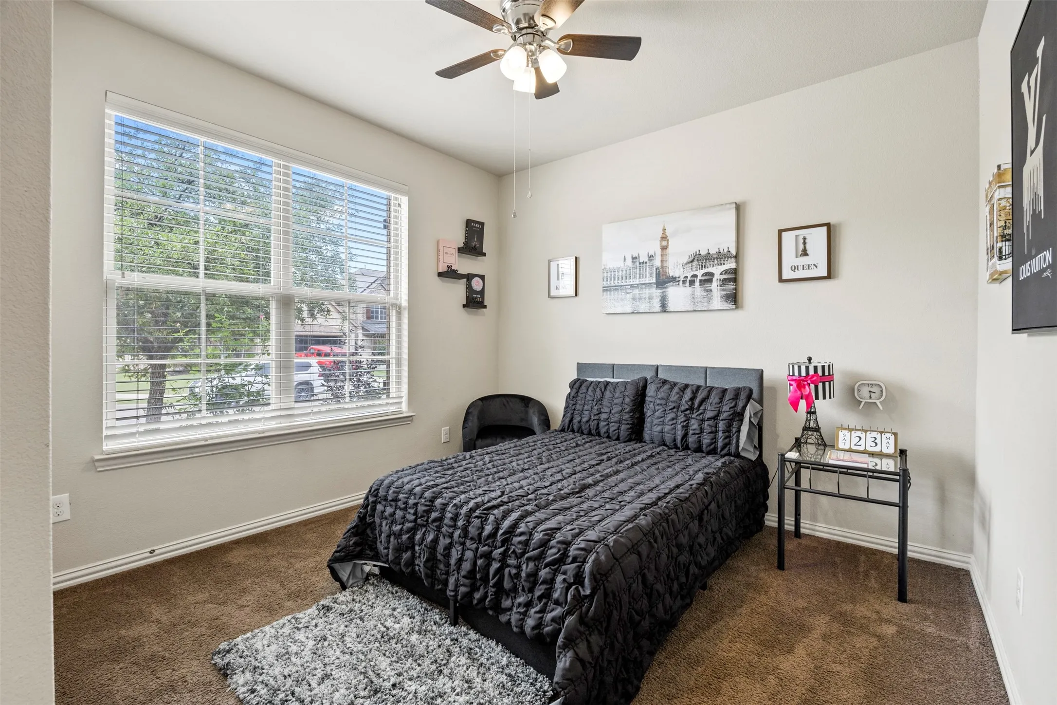 Carpeted room featuring a large multi-pane window with blinds, a ceiling fan with integrated lighting, and a neutral wall color