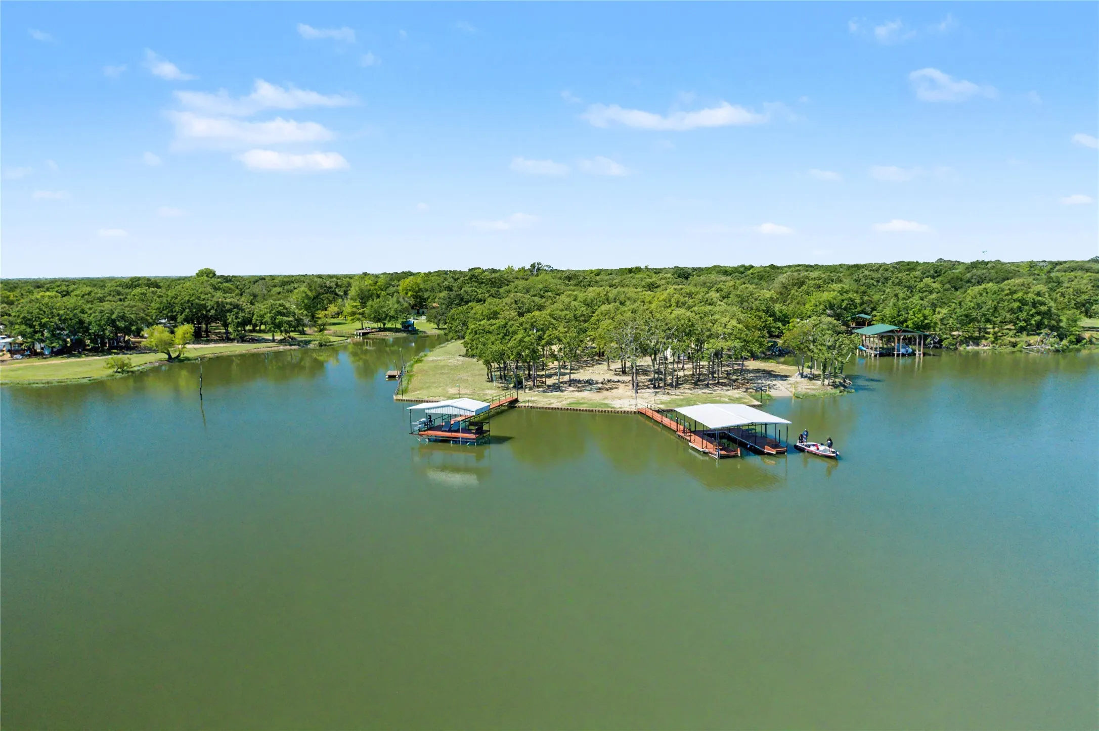 Expansive lakefront property featuring multiple boat docks with covered slips