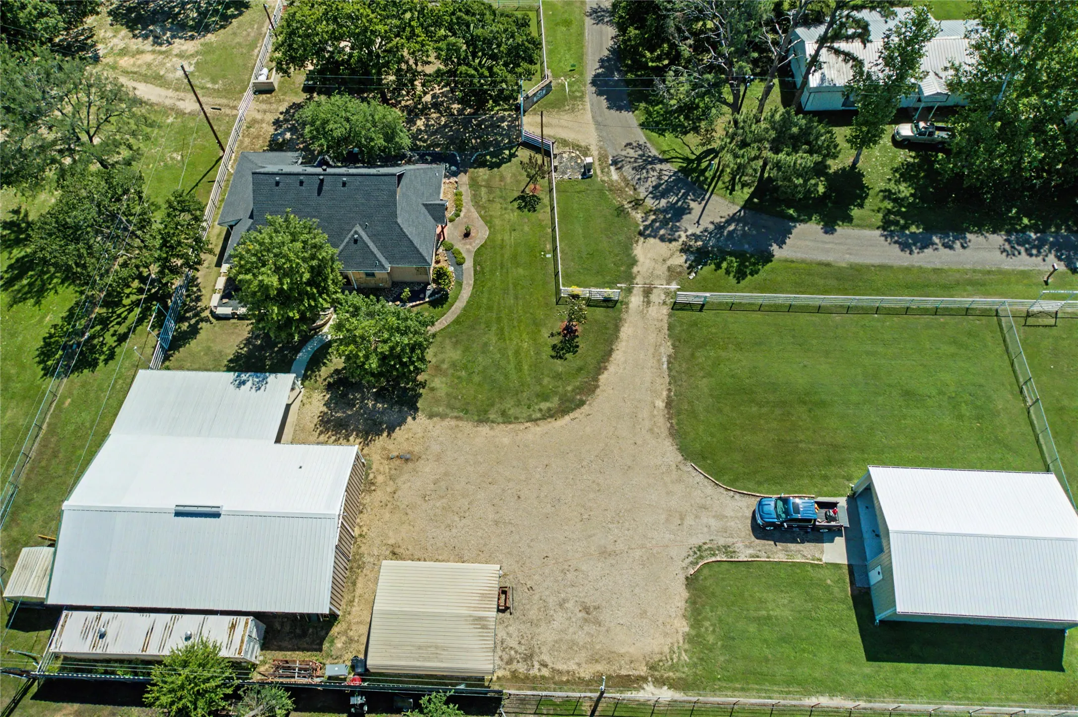 Expansive property featuring a residence, multiple outbuildings, and large open areas