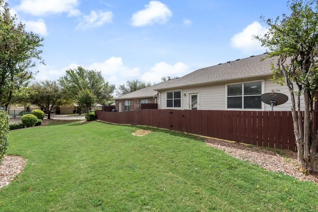 Expansive green lawn with mature trees and shrubbery