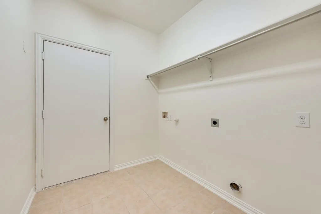 Dedicated laundry area featuring a tiled floor and neutral wall tones