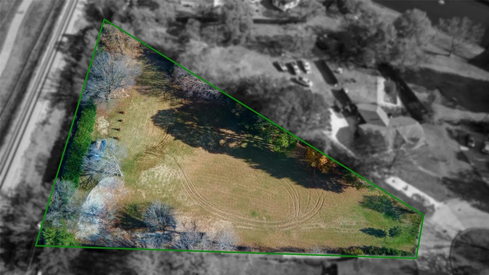 Edited...Expansive triangular parcel featuring varied tree coverage and a large open field with home removed