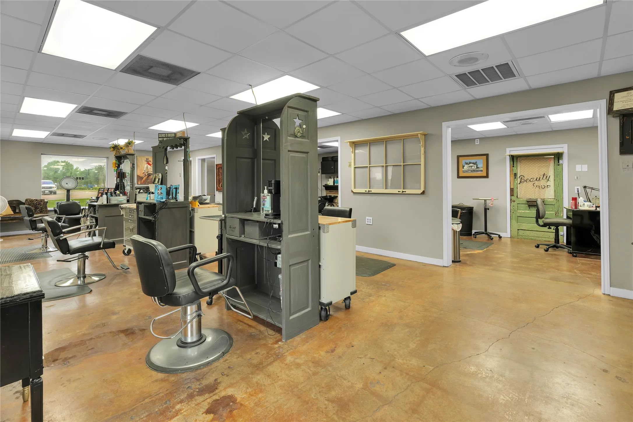 Open commercial space featuring stained concrete flooring and drop ceiling
