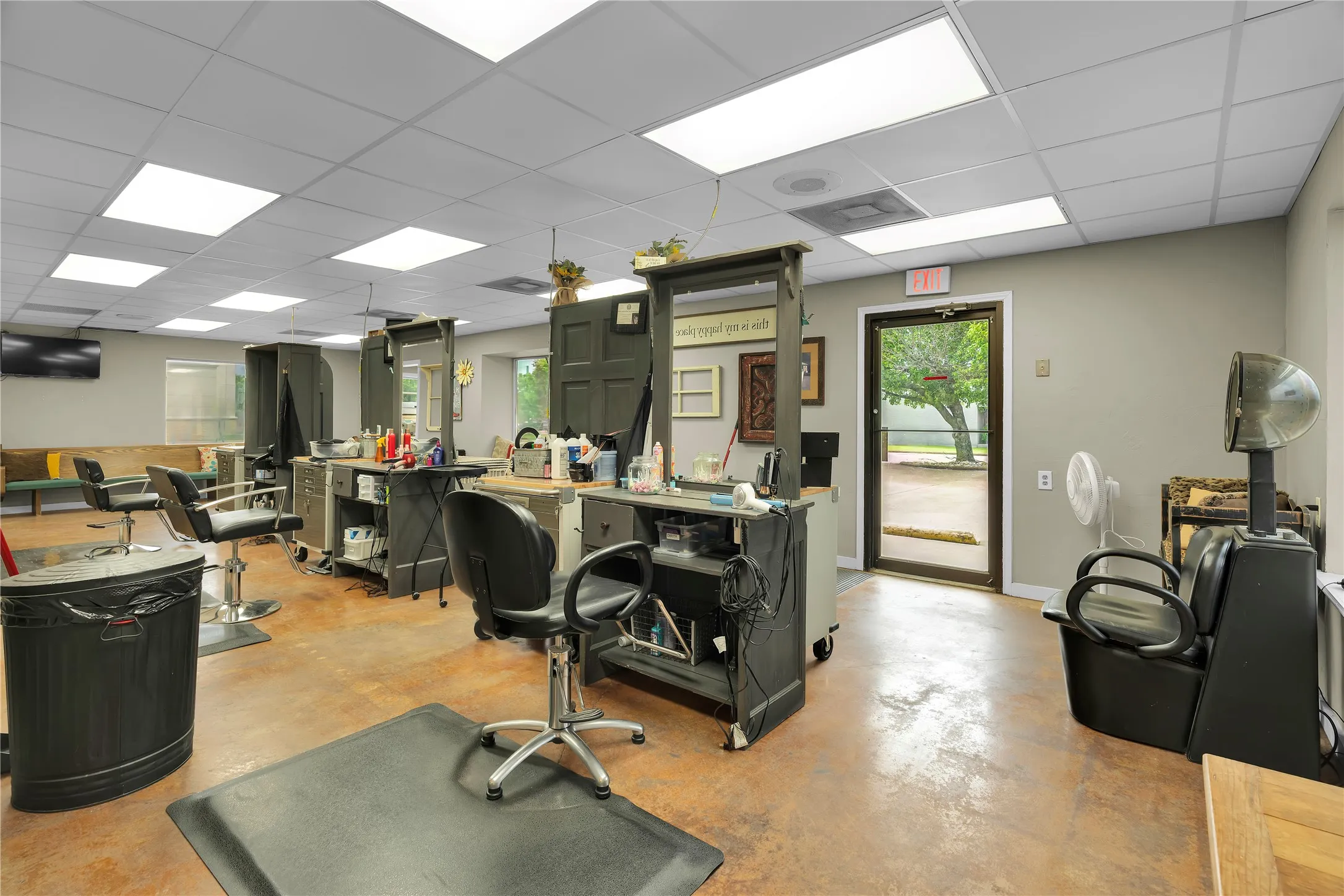 Commercial interior featuring stained concrete flooring, recessed lighting, and a grid ceiling