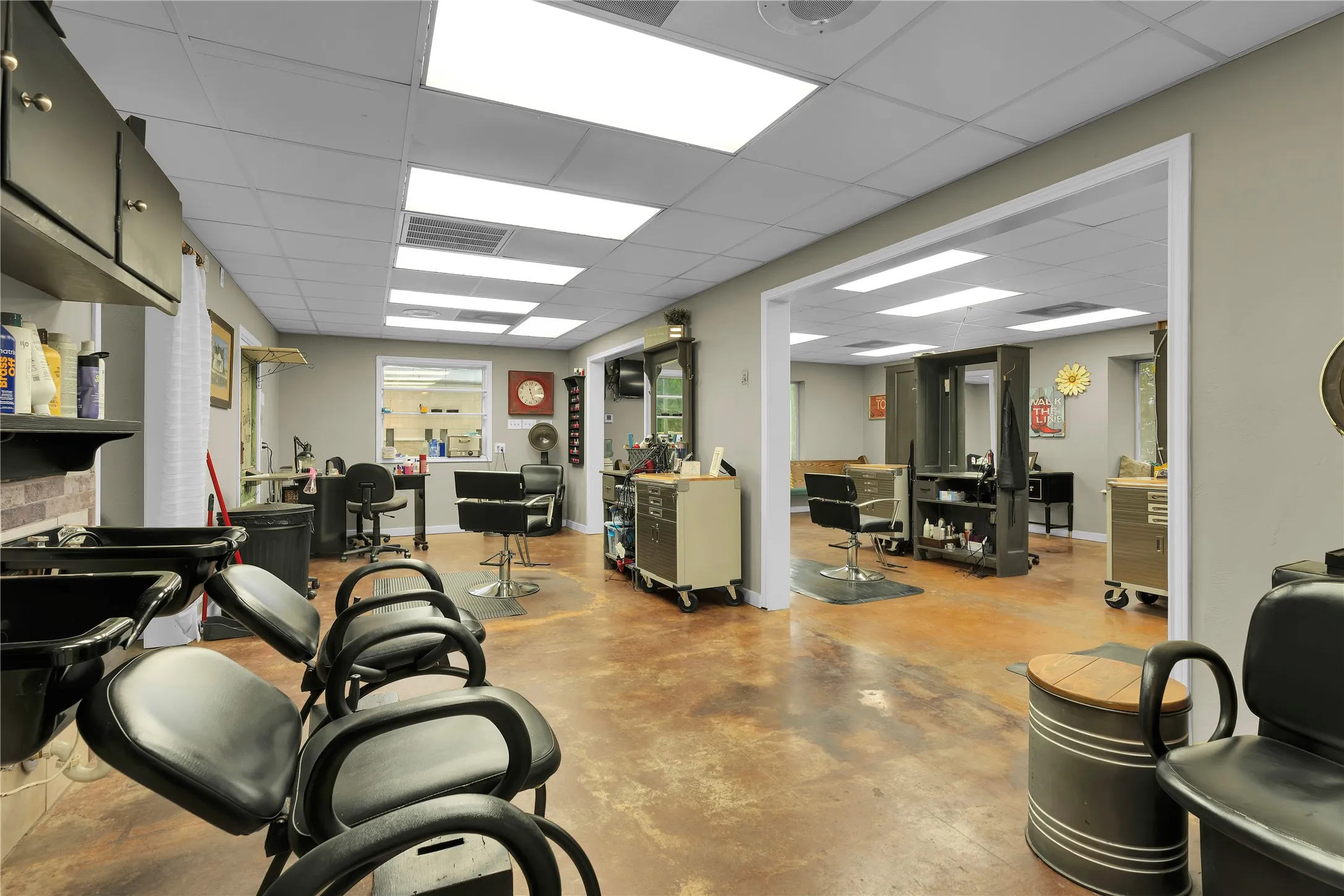 Spacious commercial interior featuring concrete flooring, recessed lighting, drop ceiling, and a wide entryway