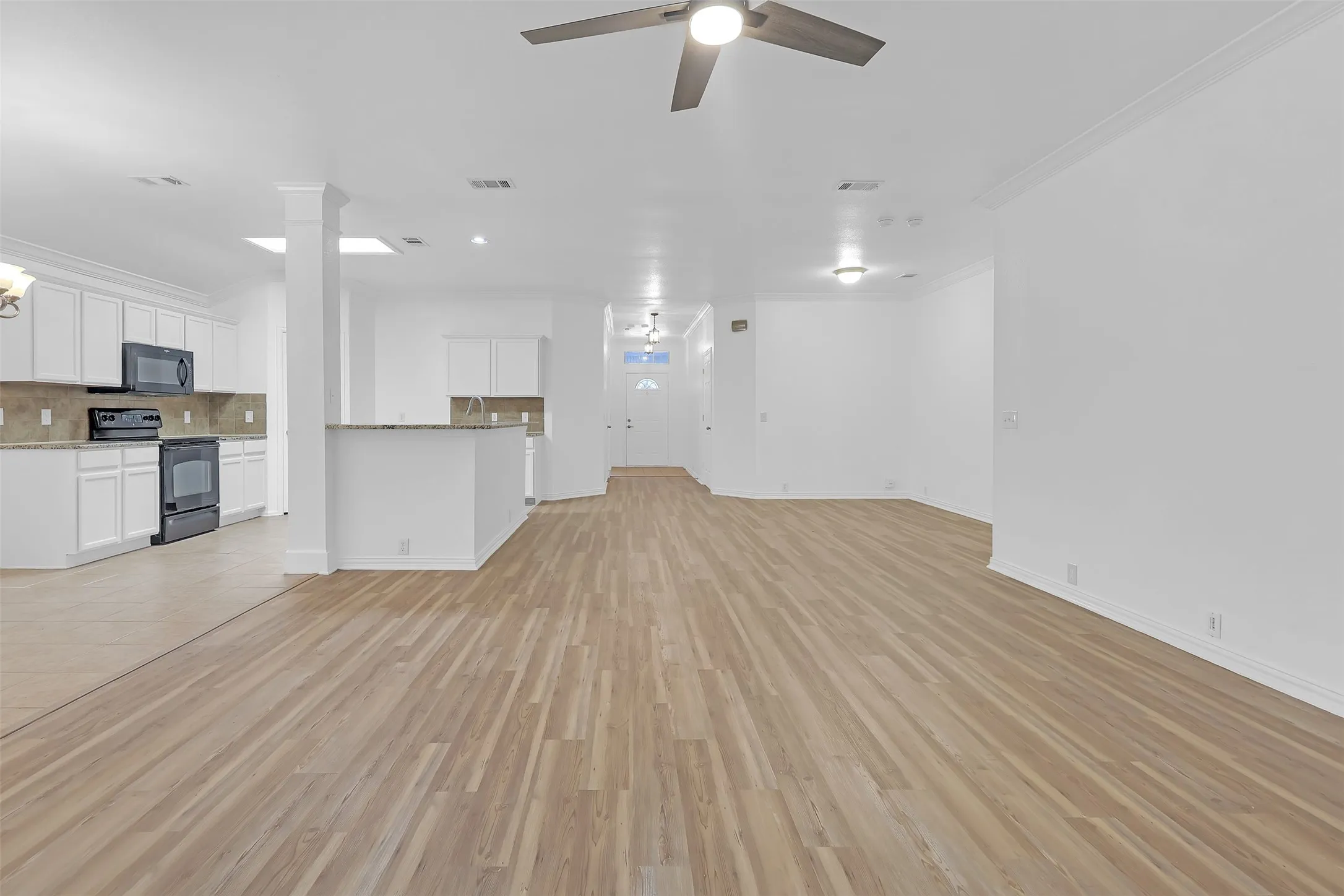 Unfurnished living room with crown molding, a ceiling fan, light wood-style flooring, and recessed lighting