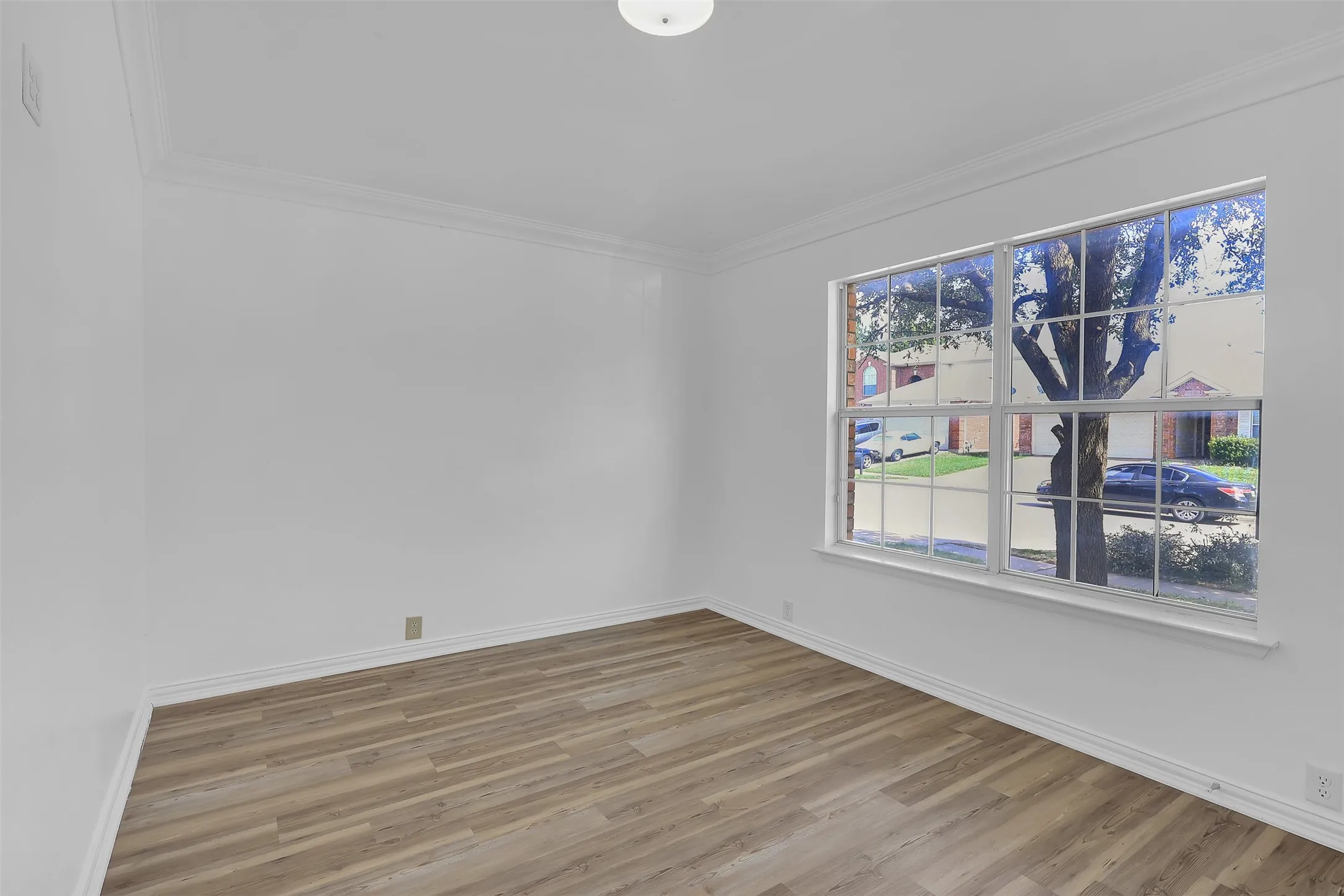 Empty room with wood finished floors and ornamental molding