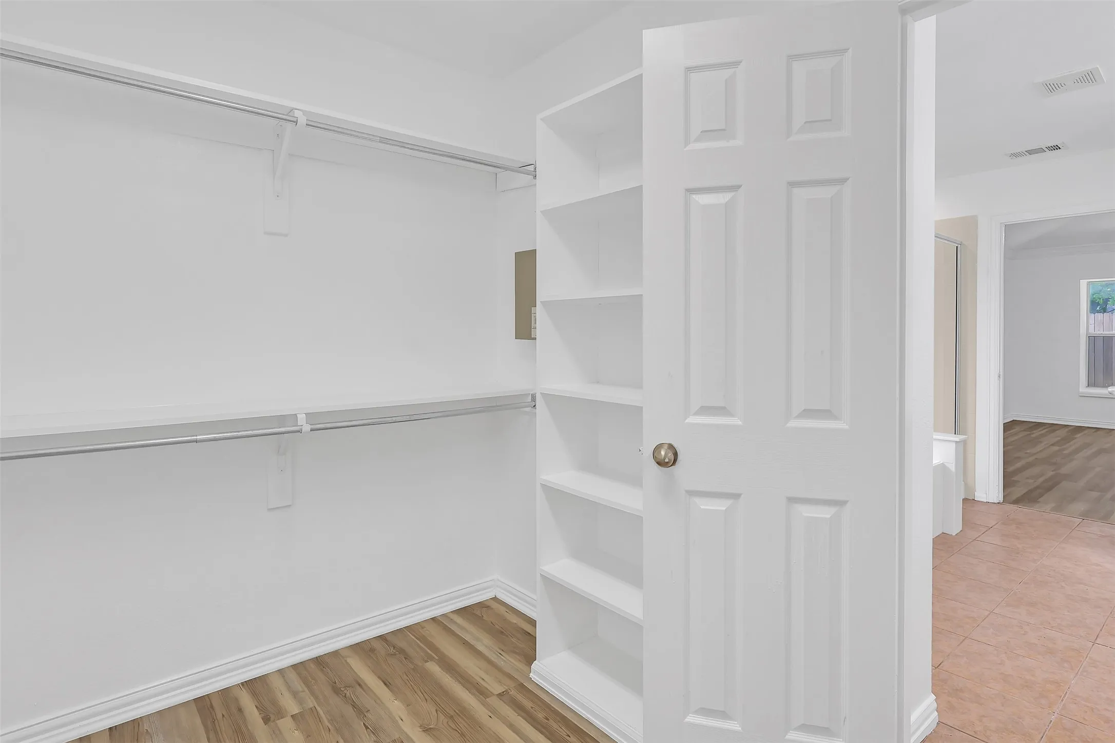 Walk in closet with wood finished floors