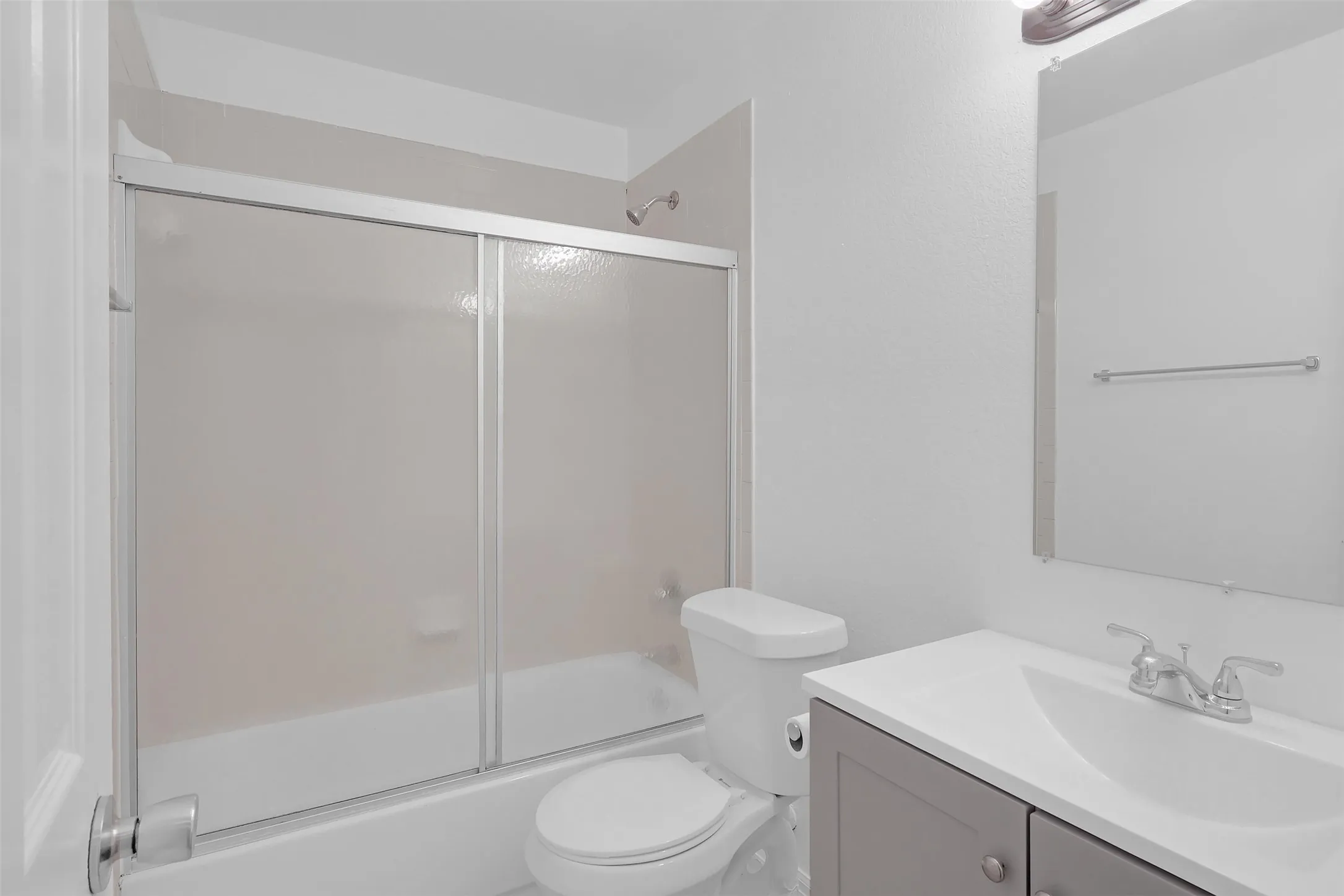 Bathroom featuring vanity and combined bath / shower with glass door