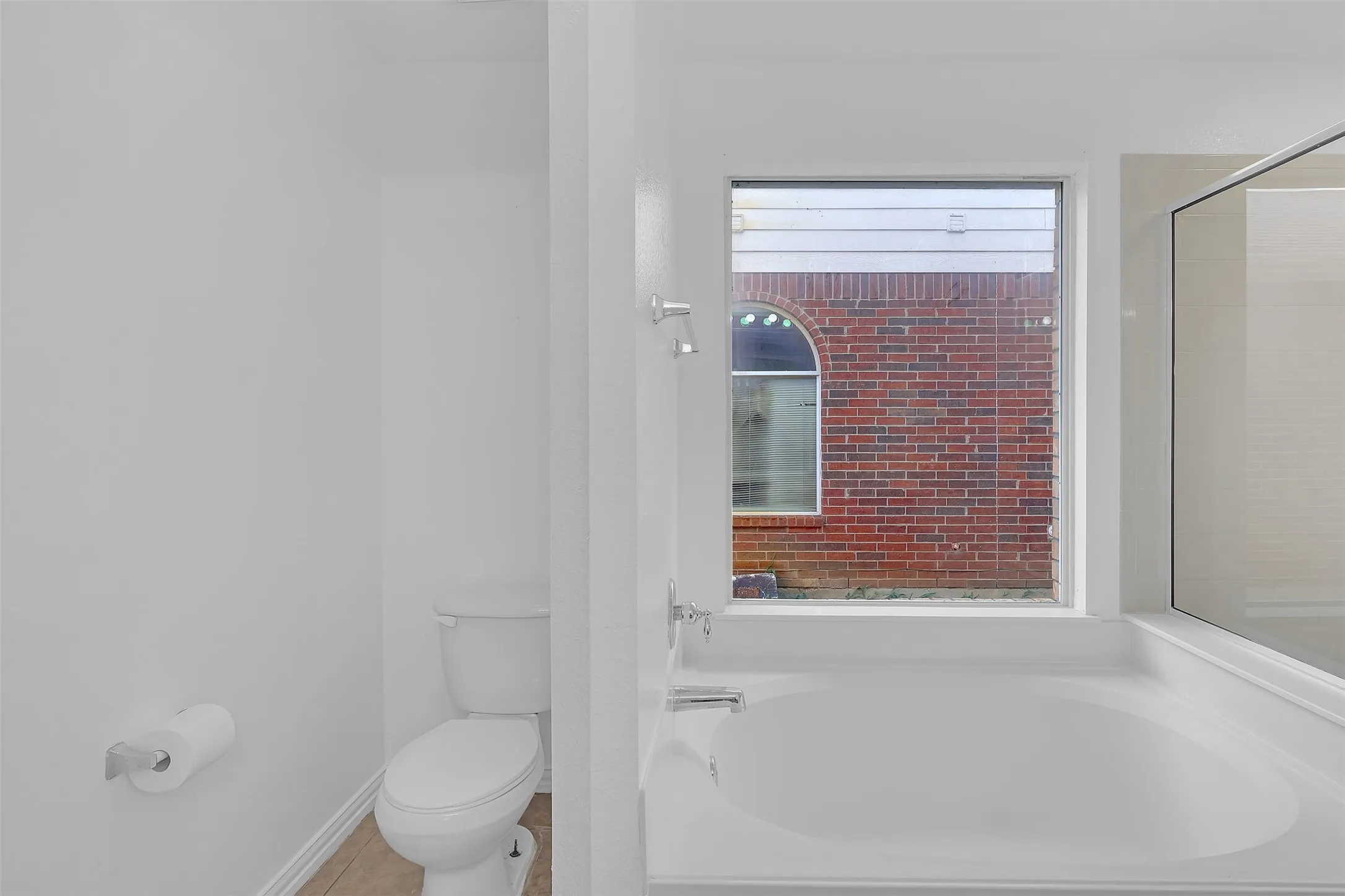 Full bathroom featuring a bath and toilet