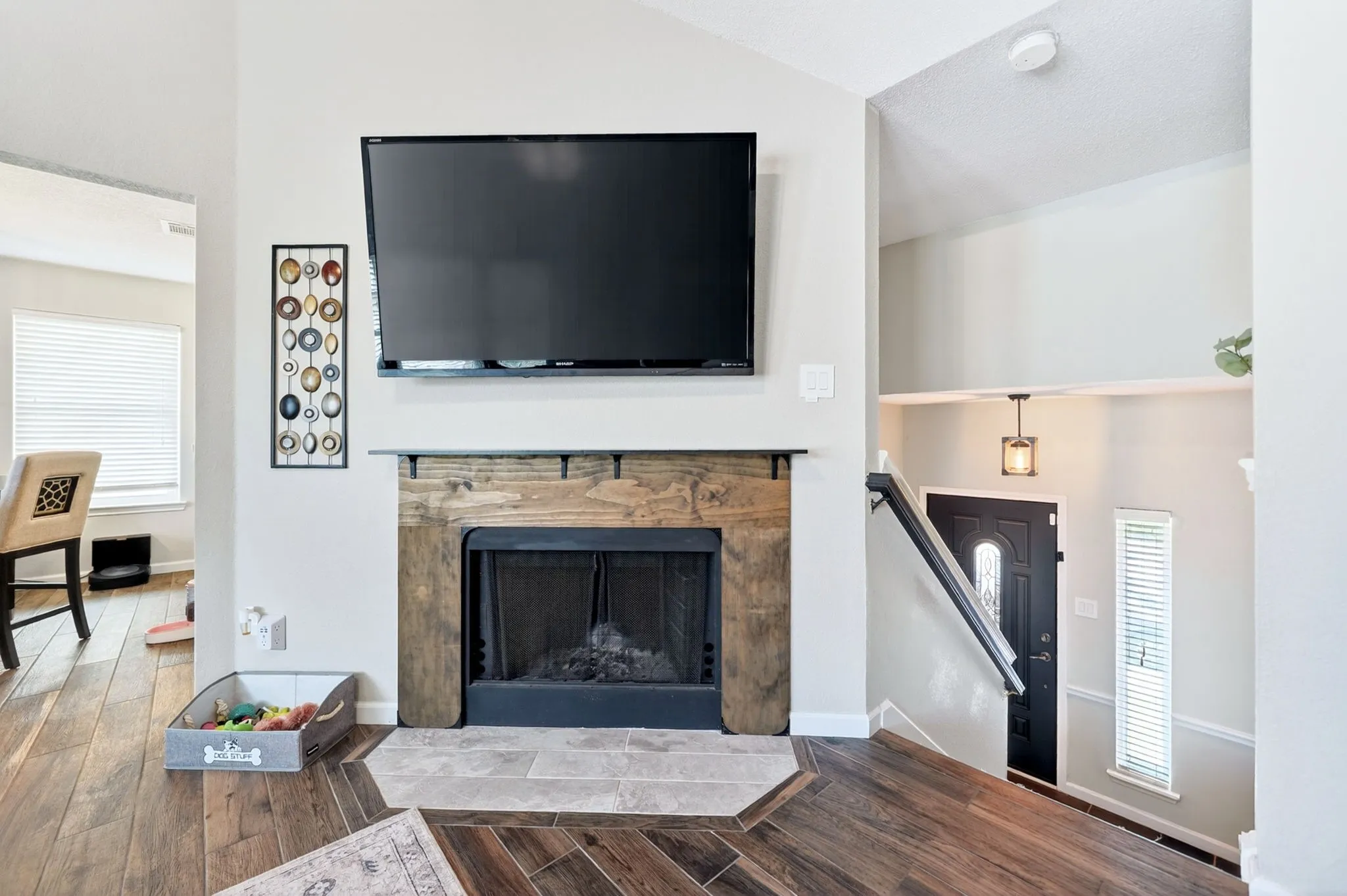 Fireplace with rustic wood mantel and hearth featuring light-toned tilework