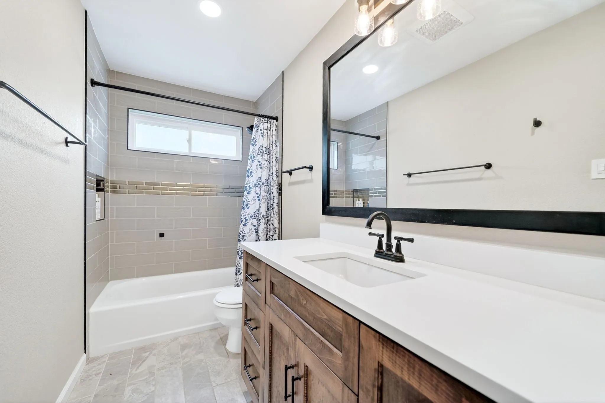 Modern bathroom vanity featuring a solid surface countertop with an integrated sink and matte black faucet