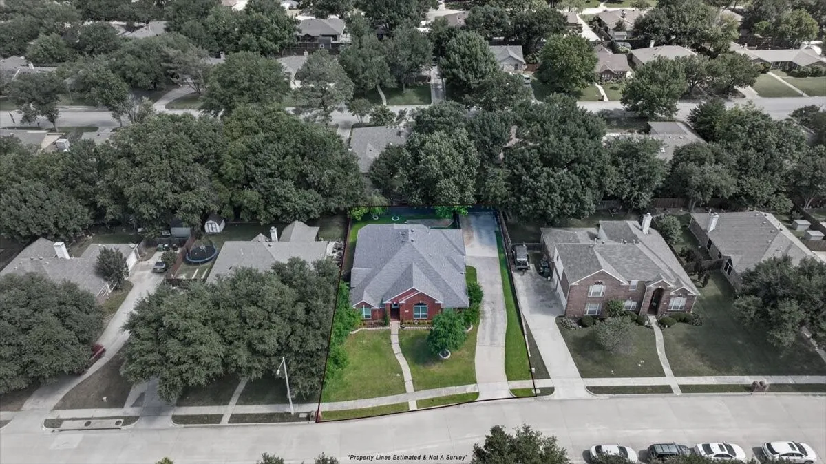 Traditional brick residence featuring a gray shingle roof, established front lawn, and concrete driveway