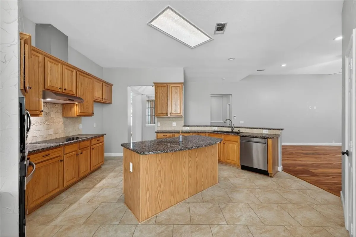 Kitchen featuring a central island with countertop, extensive wood cabinetry, and stainless steel appliances
