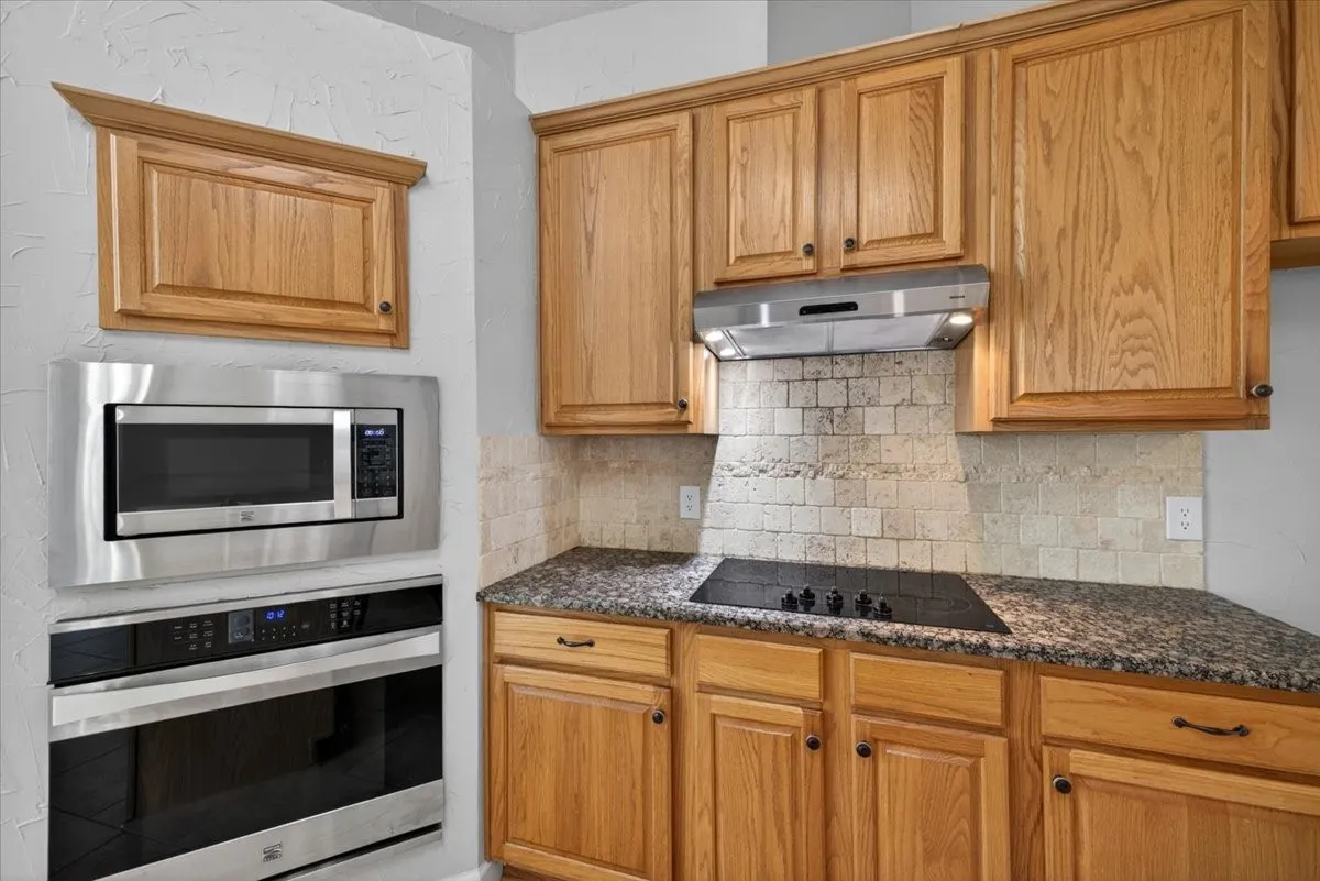Kitchen featuring wood cabinetry, a built-in microwave, and a wall oven