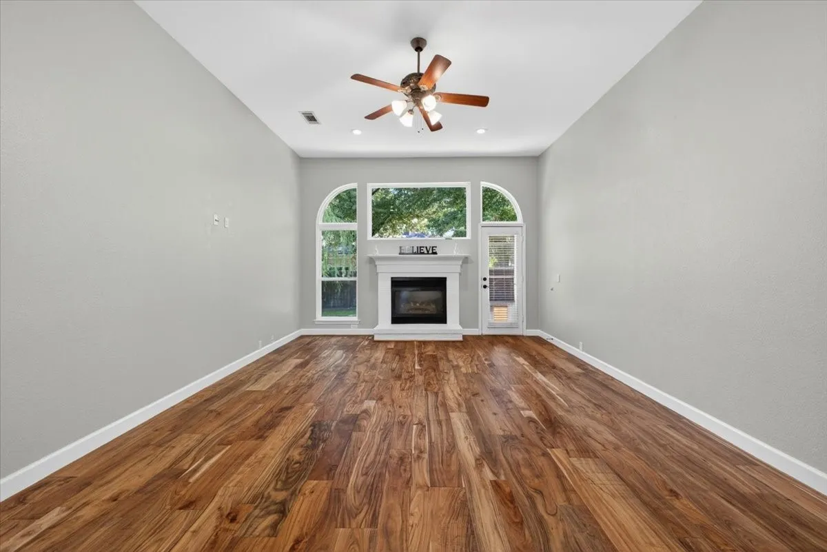 Spacious room featuring wood-finish flooring and light gray walls