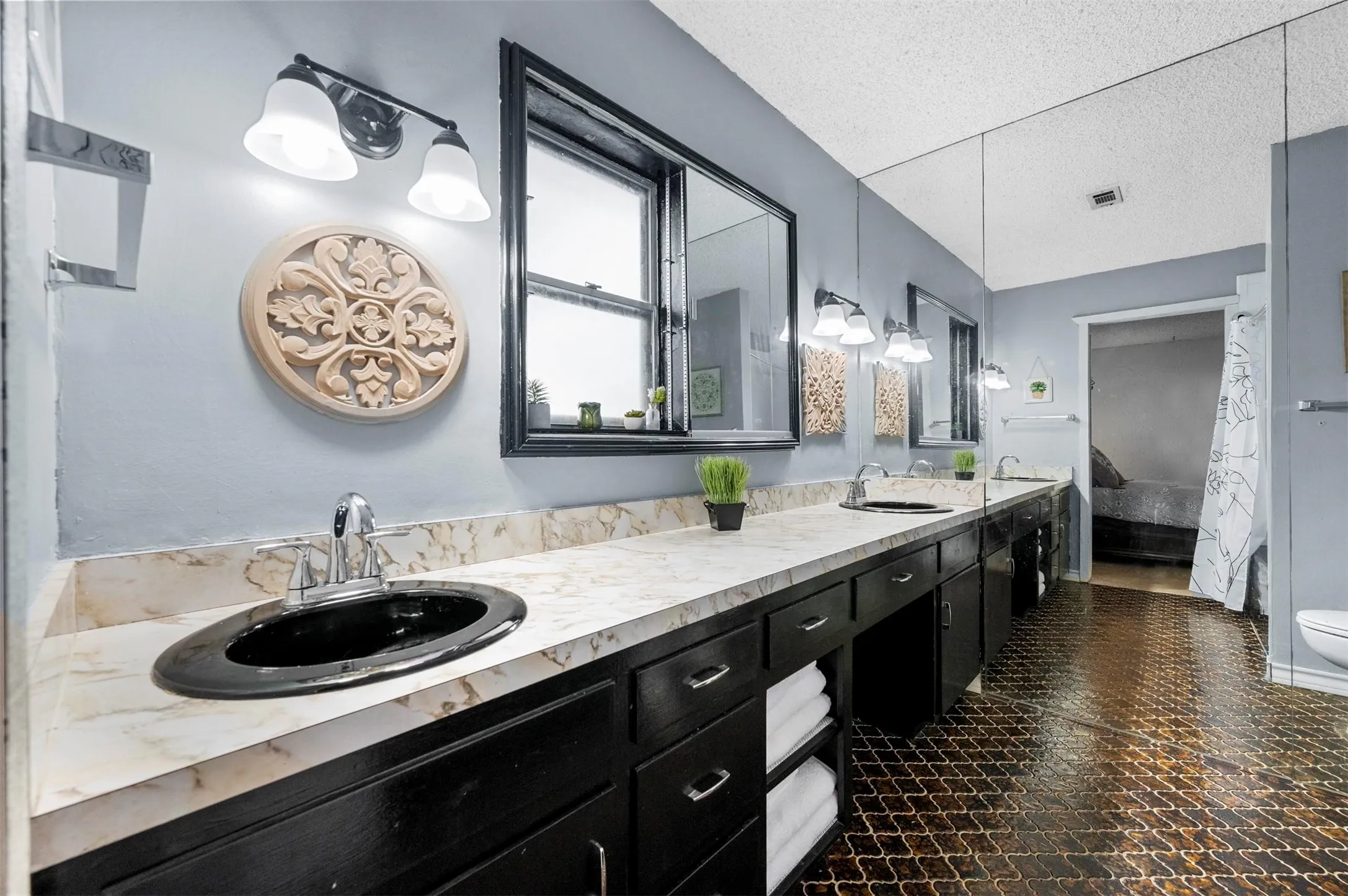 Dual vanity with black cabinetry and light-toned countertops