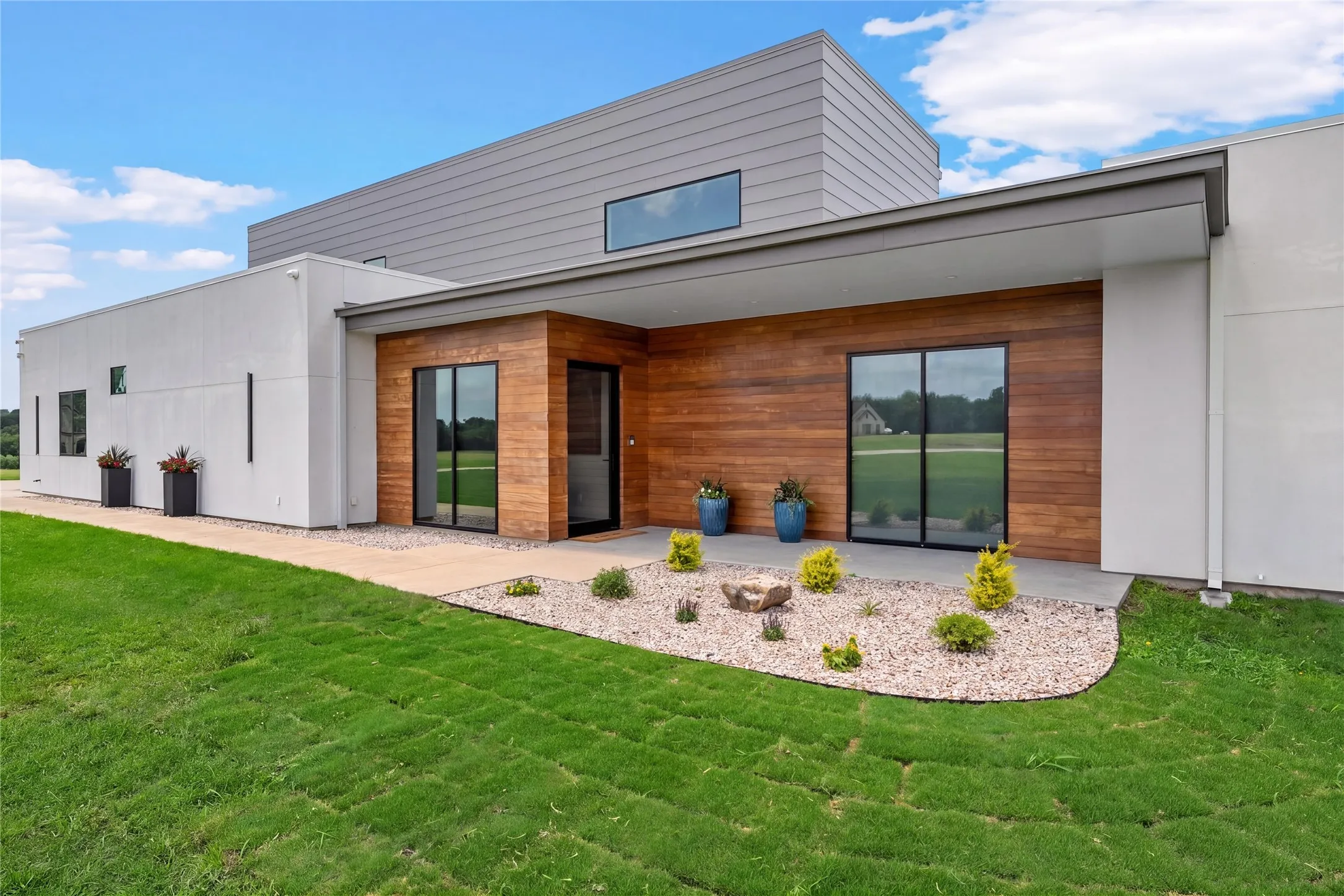 Contemporary architectural design featuring wood-finish siding, white stucco, and horizontal metal siding