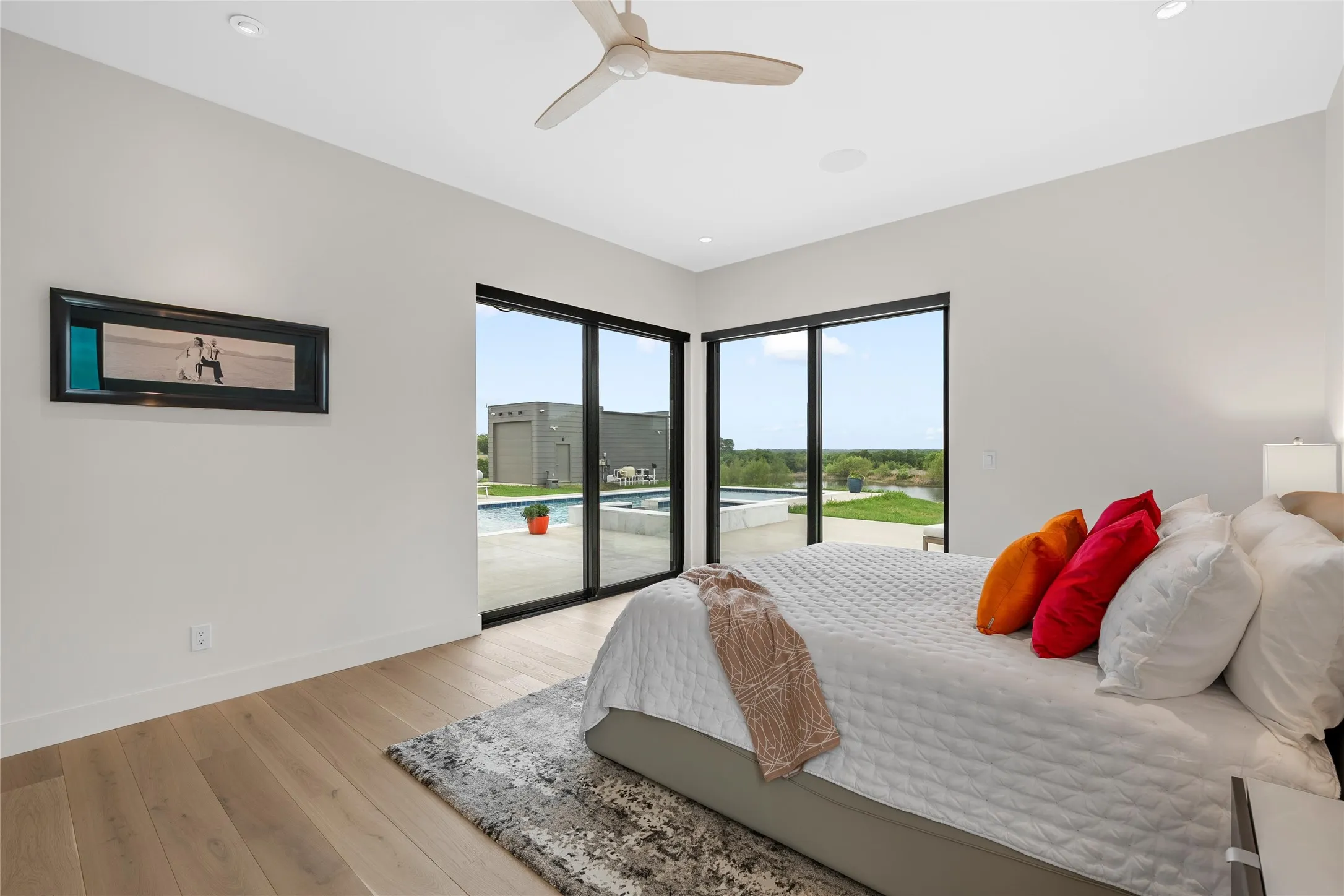 Expansive room featuring multiple full-height windows, wood-finish flooring, and recessed ceiling lighting