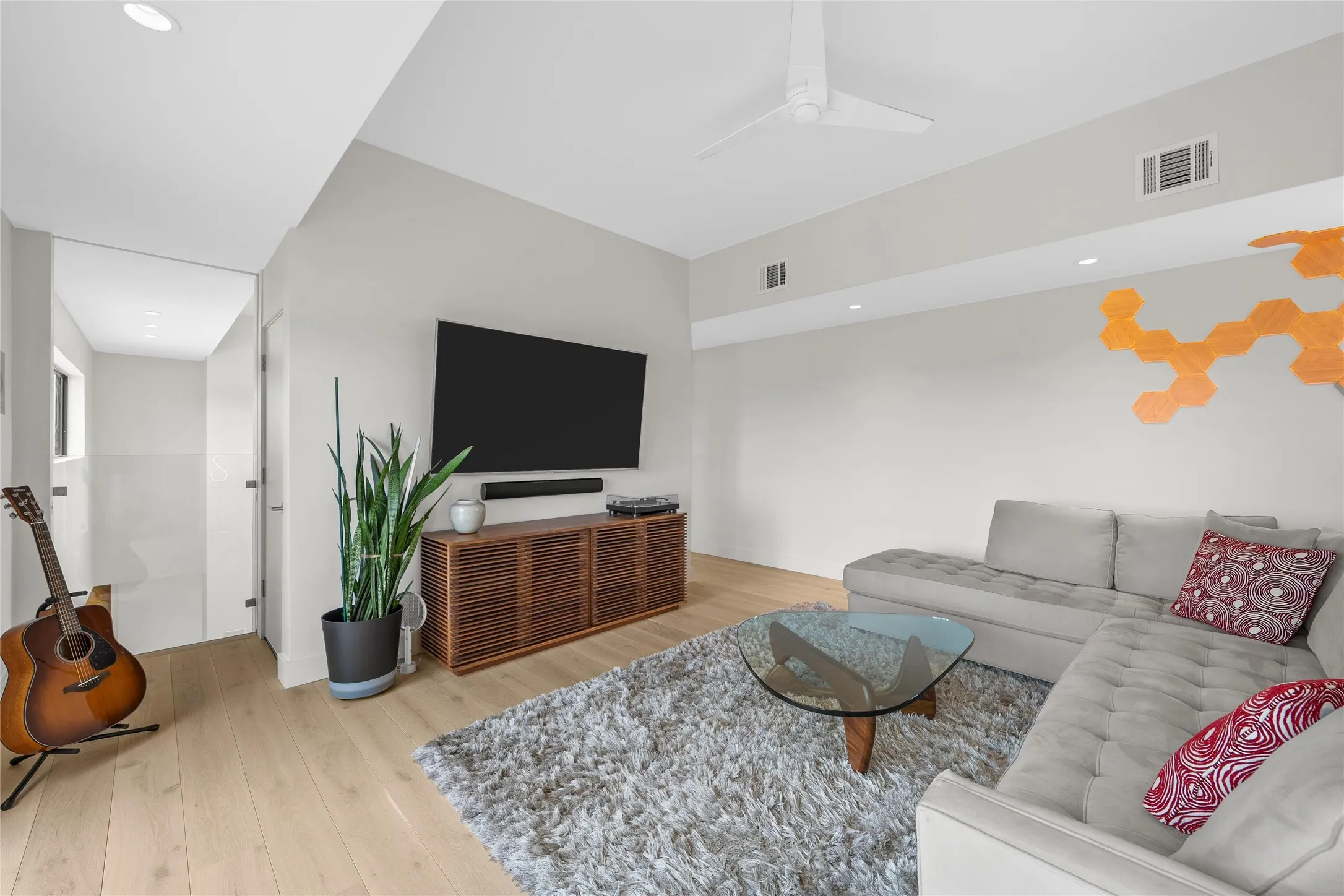 Living area featuring light wood-finish flooring, recessed lighting, a modern ceiling fan, and a built-in media console