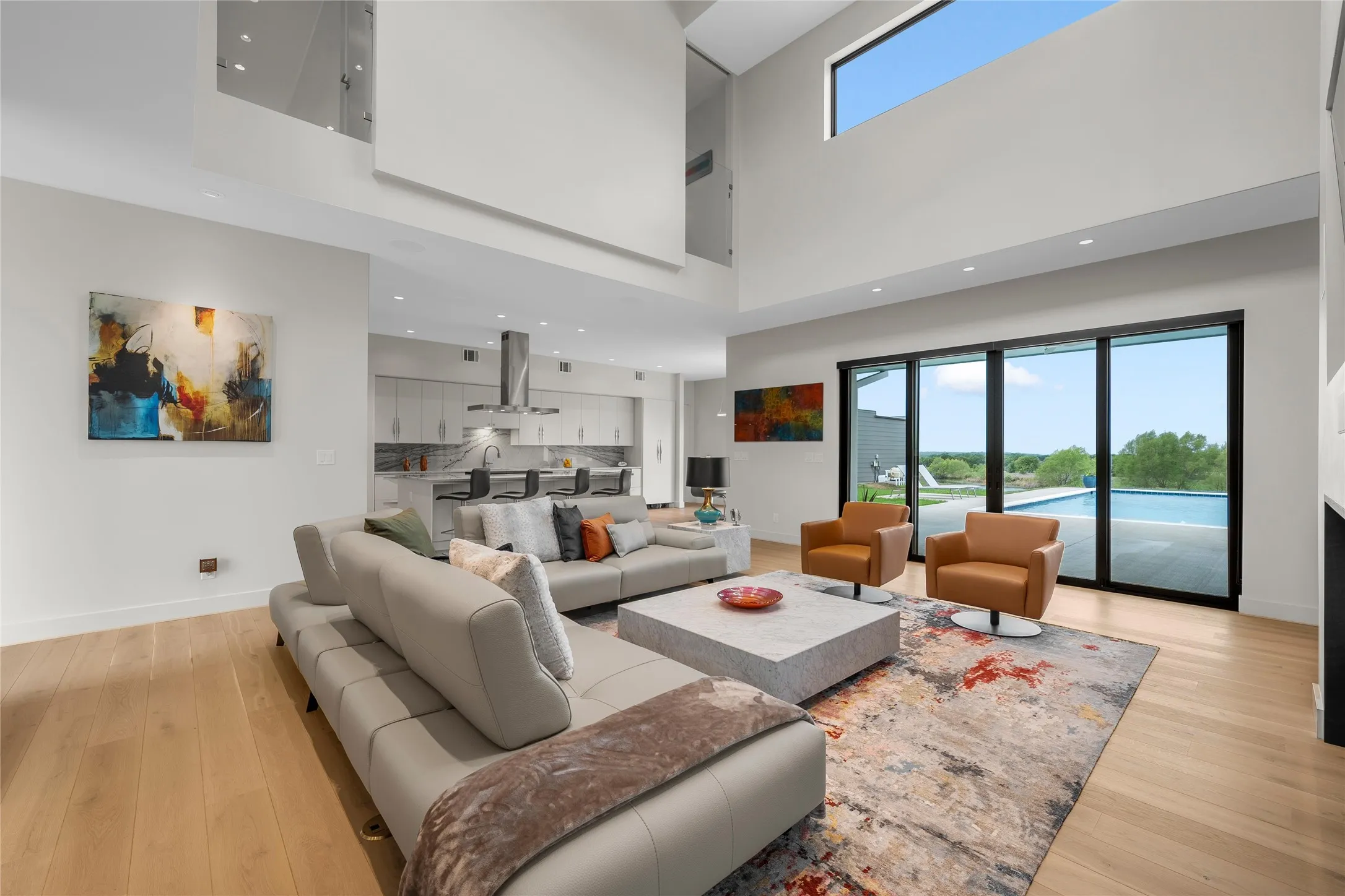 Open-concept living area with soaring ceilings and light wood-finish flooring