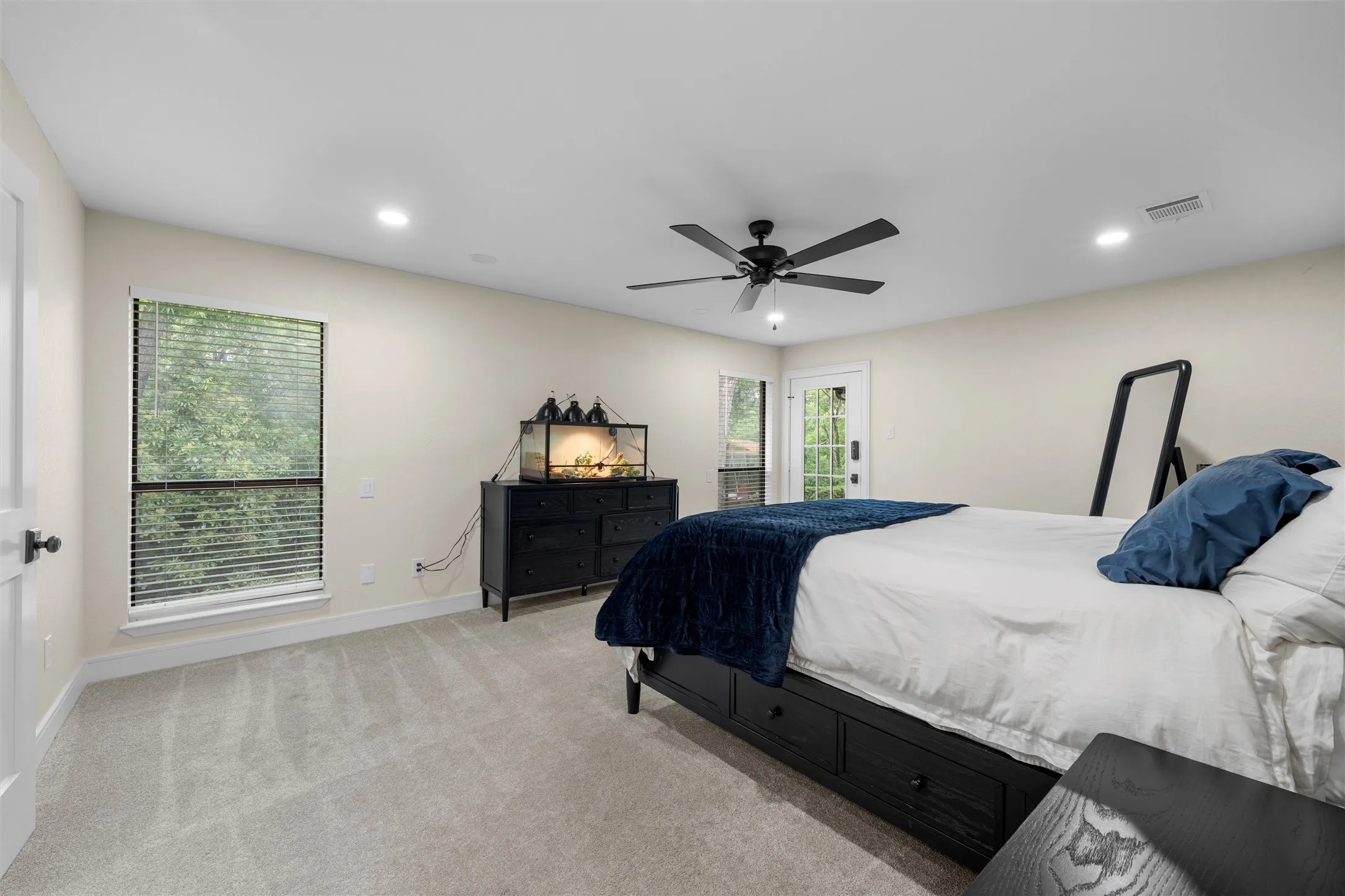 Spacious room featuring light-colored walls and soft carpet flooring