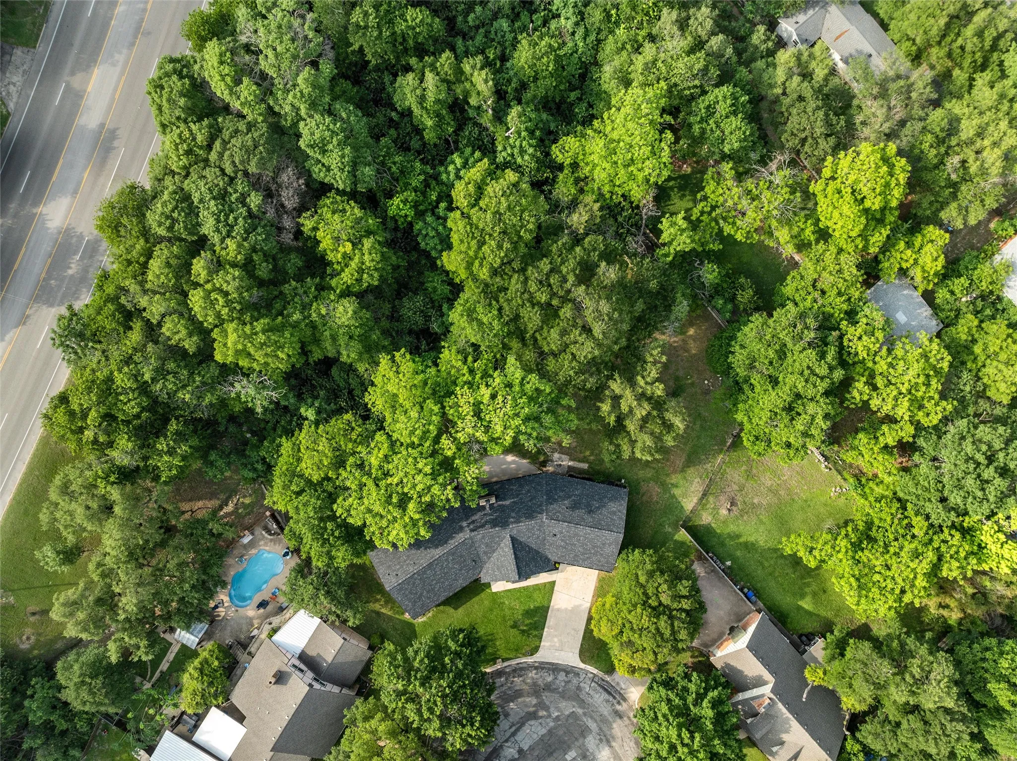 Aerial perspective showcasing a property surrounded by mature trees